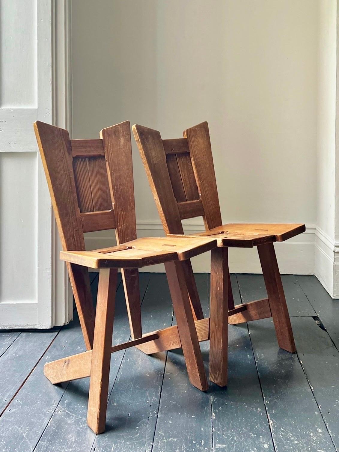Paire de chaises d'appoint ou de chaises de salle, début du 20e siècle. Chaises en pitch-pin avec des joints à tenons et mortaises apparents et une silhouette architecturale saisissante.

Jolie fabrication et beaucoup de caractère ; bon état