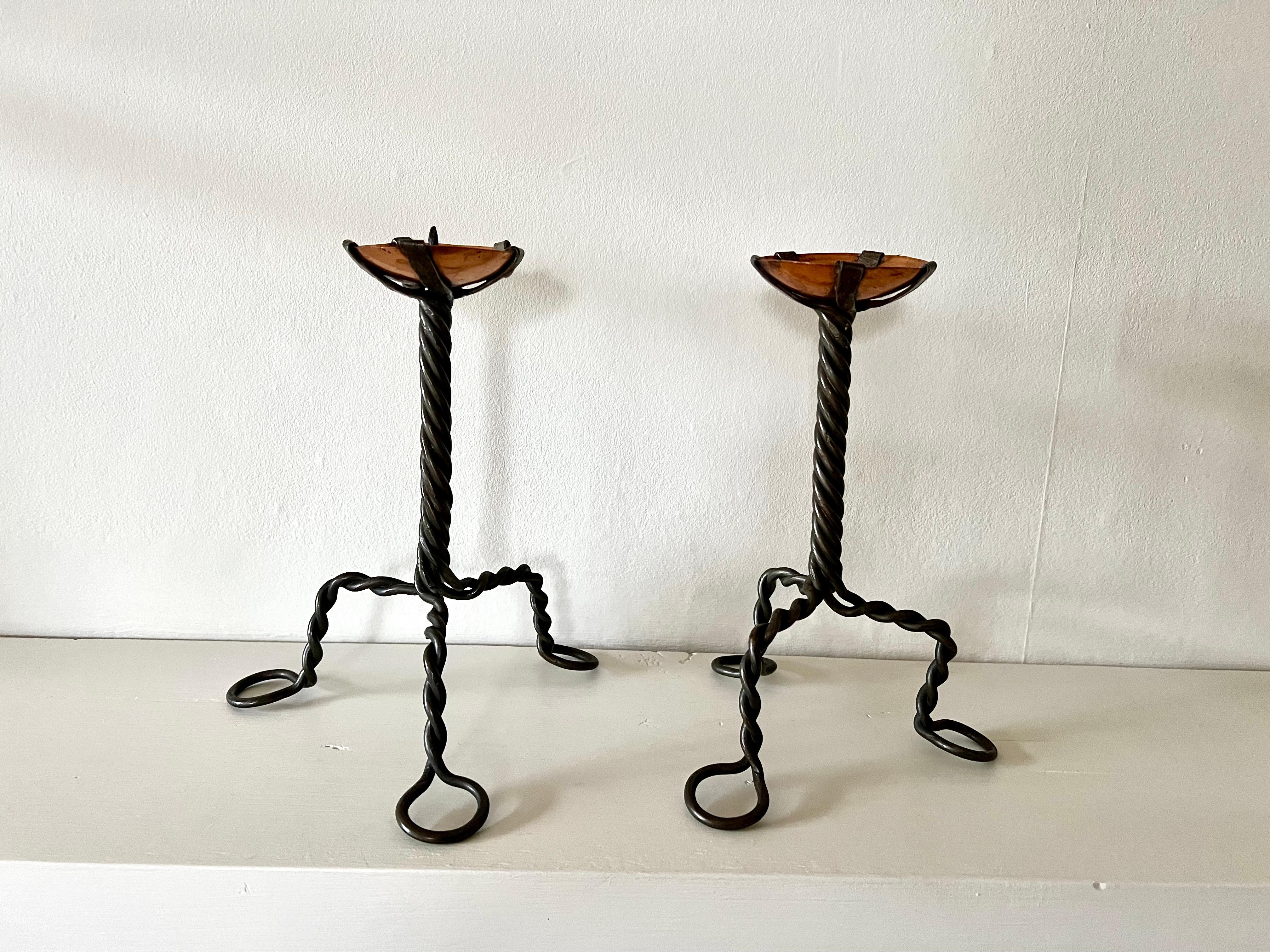 Coppia di portacandele Arts & Crafts dell'inizio del XX secolo.

Costruito da un fusto in ferro battuto ritorto con una ciotola aperta in rame.

In buone condizioni originali, nessun danno, patina e segni dell'età come da foto.

Dimensioni (cm): 21h