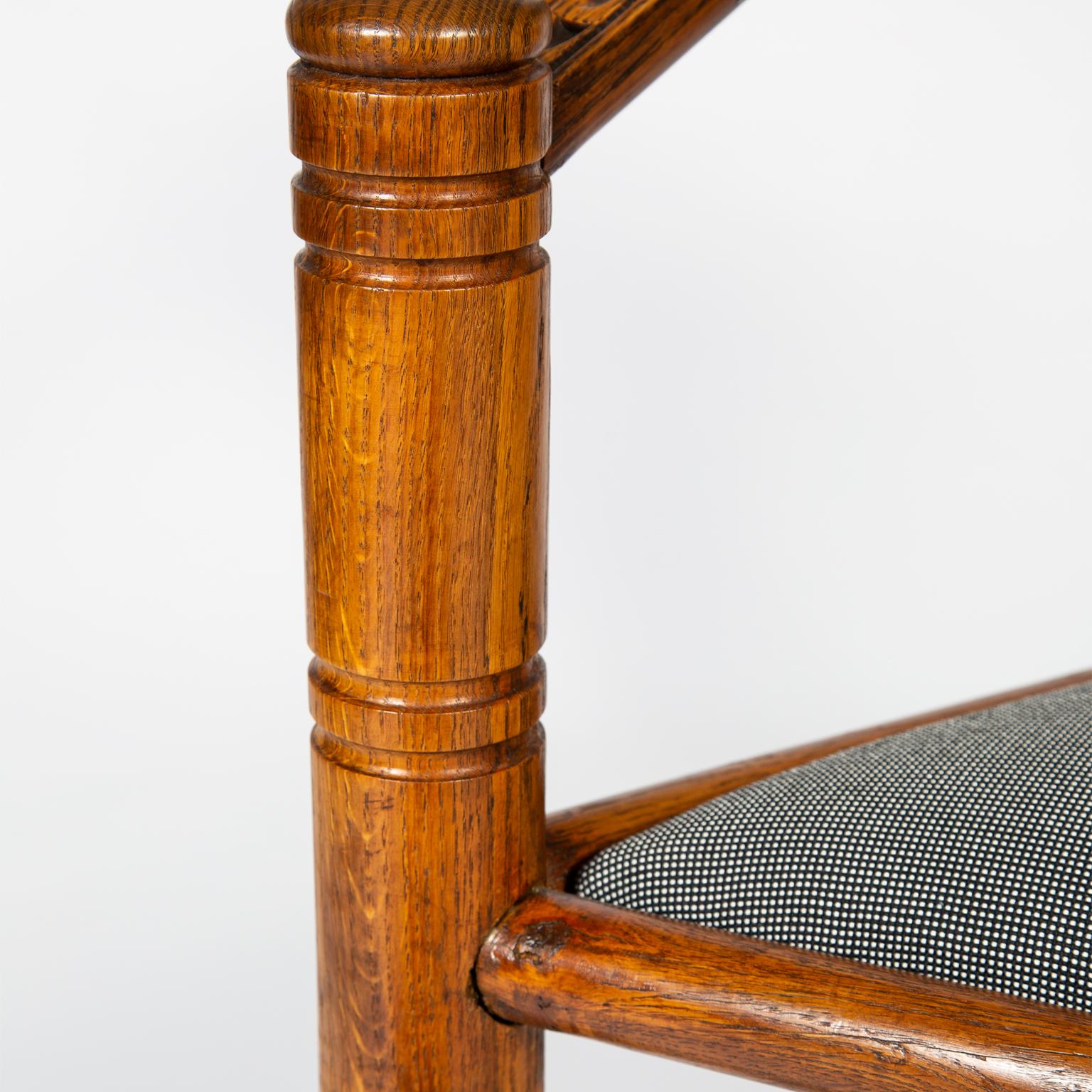 A pair of armchairs in the Arts & Crafts manner, made from solid oak with geometric chip carved details and turned legs, in the style of John Starkey. Upholstery in black and white 'Pro 3' classic plain weave fabric designed by Finn Sködt for