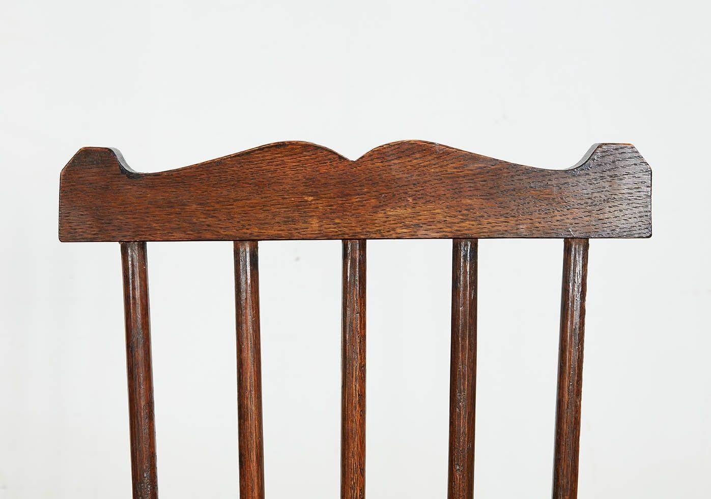 Paire de fauteuils Windsor Arts & Crafts de forme personnalisée, avec de hauts dossiers en éventail, un rail façonné sur quatre fuseaux, un bras continu soutenu par un fuseau en bois courbé et des sièges sellés (nb : les sièges sont d'une profondeur