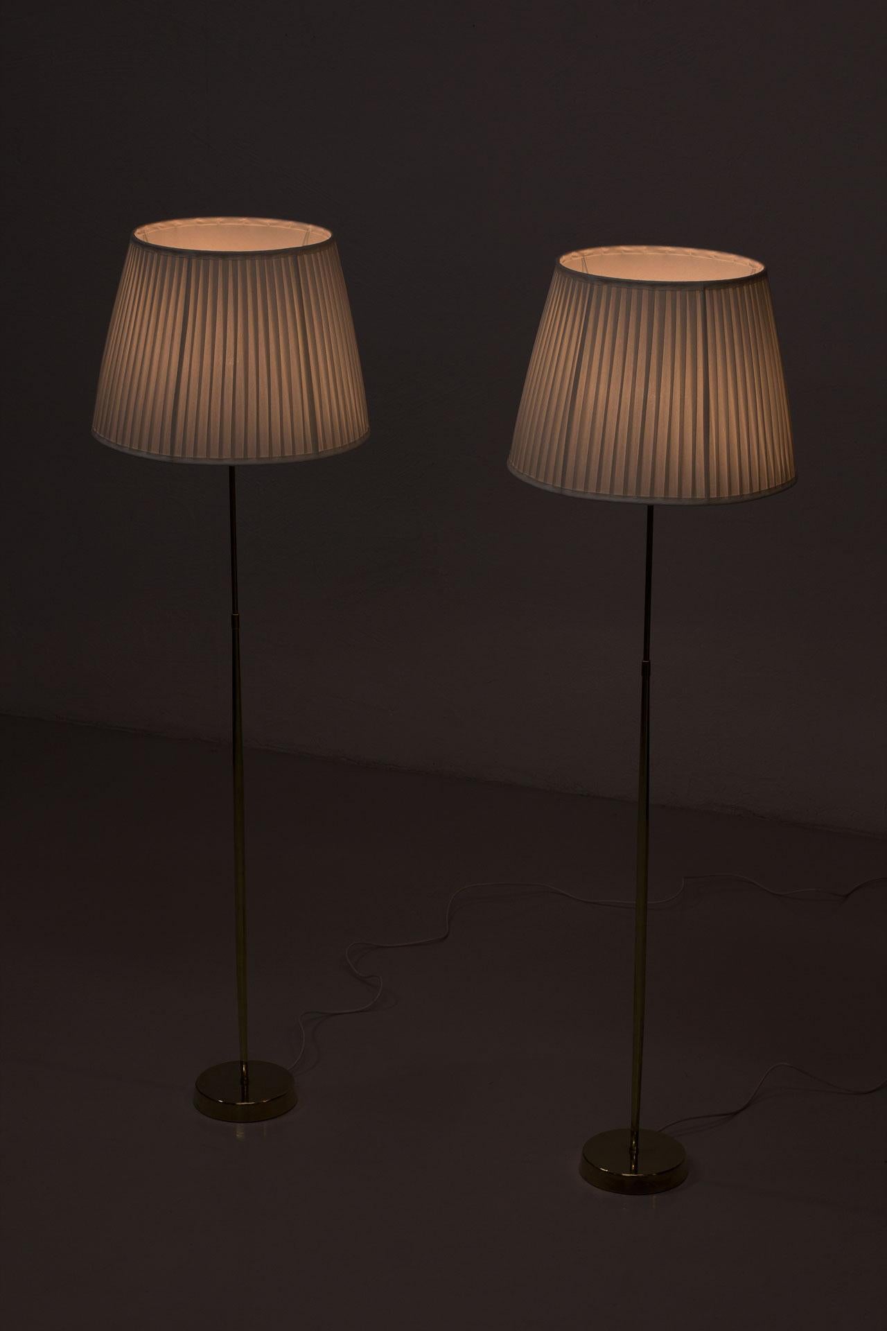 20ième siècle Paire de lampadaires en laiton ASEA Belysning, années 1950, abat-jour en chintz plissé à la main en vente