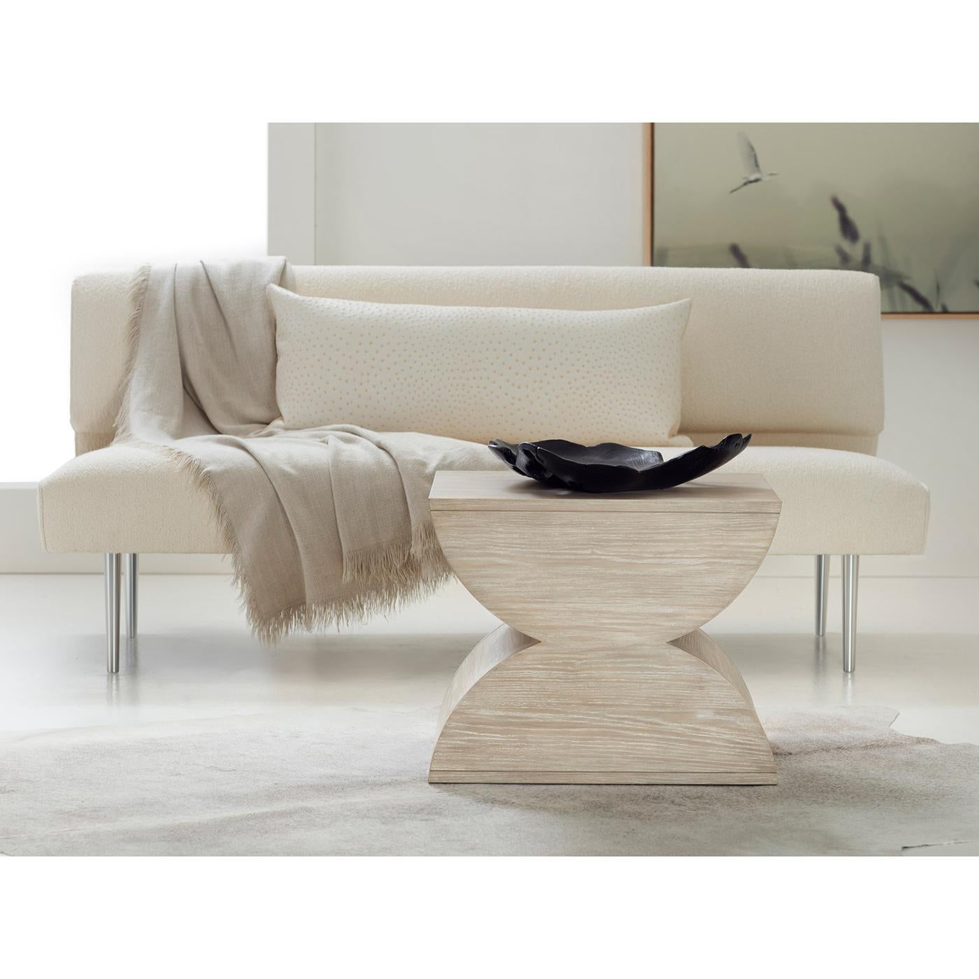 La silhouette distinctive crée une déclaration géométrique audacieuse, tandis que la finition en bois de cendré clair apporte une luminosité contemporaine à tout espace. Cette pièce fabriquée de main de maître présente des motifs de grain de bois