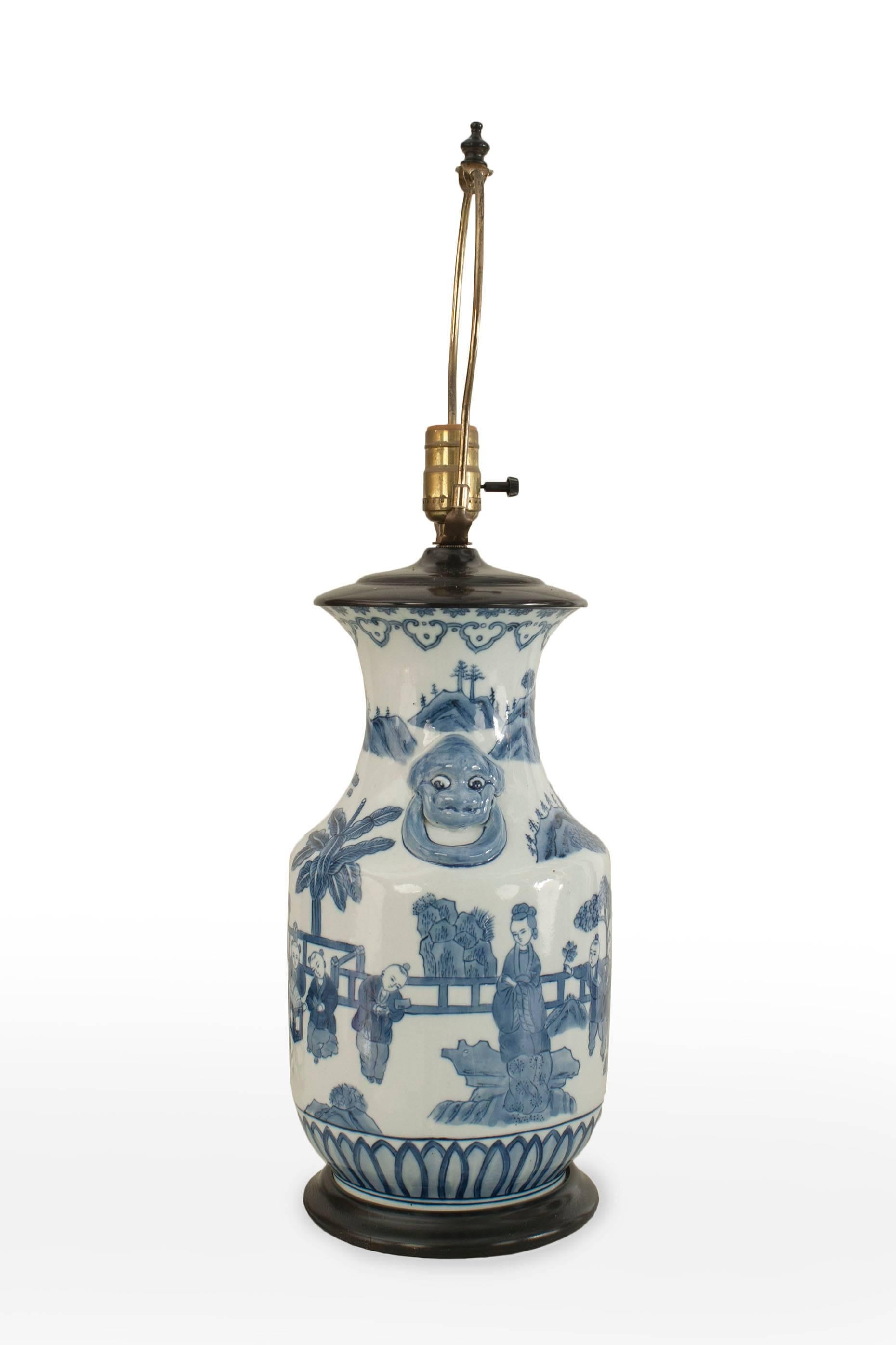 Pair of Asian Chinese style (20th Century) blue and white vase form table lamps with a scene having figures on an ebonized round base.
 