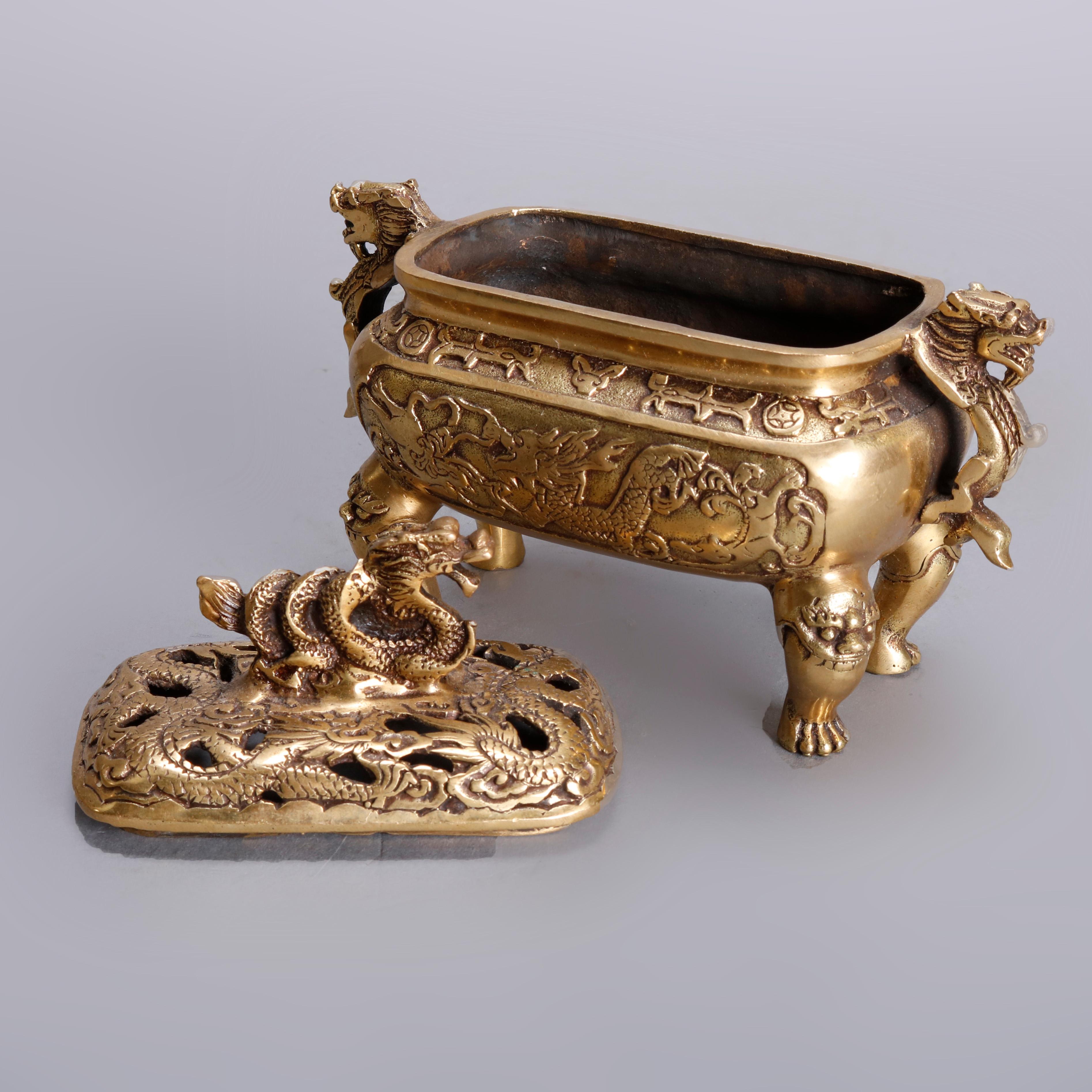 A set of Asian censers offer cast and gilt metal construction each footed, lidded with double handles, figural dragon and serpent elements, and stamped on bases as photographed, 20th century 

Measures: 5