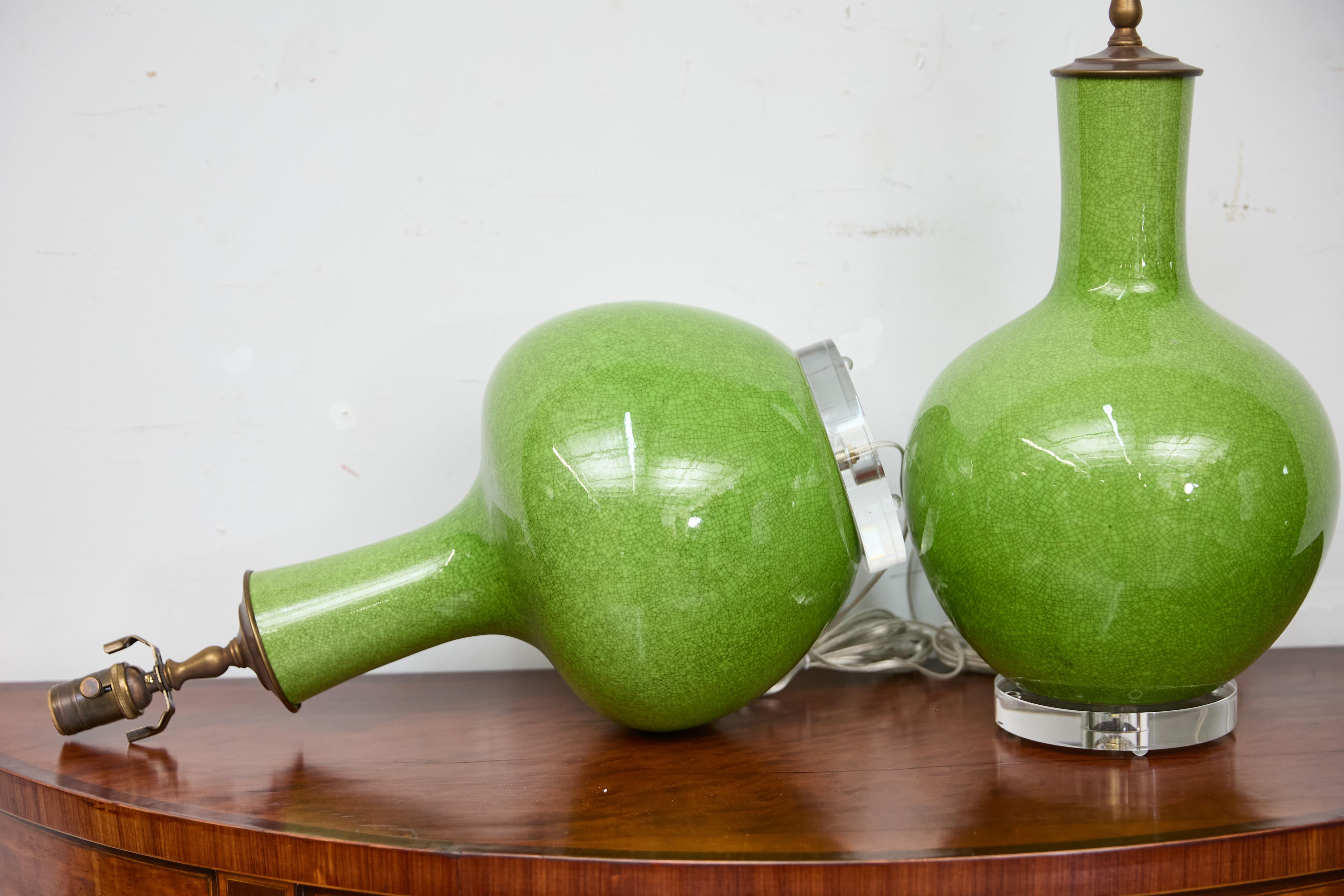 Porcellana Coppia di lampade da tavolo asiatiche in porcellana verde con effetto craquelé su basi in lucite, cablate USA in vendita
