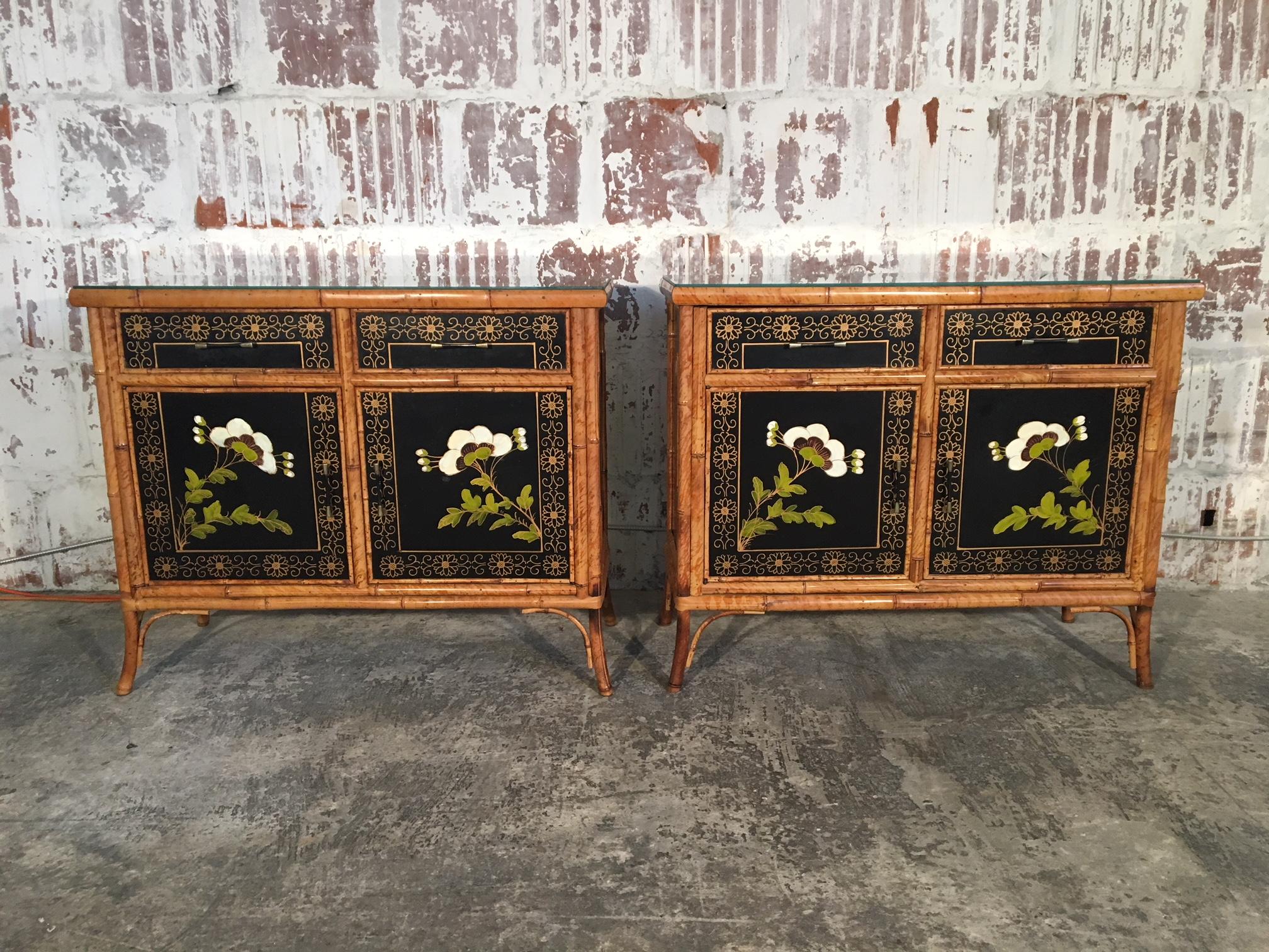 Twin Asian Chinoiserie cabinets feature hand-painted floral scenes and bamboo detailing. Dovetail joints, glass tops and brass hardware. Excellent vintage condition with minor signs of age appropriate wear. One small chip on back corner of one glass