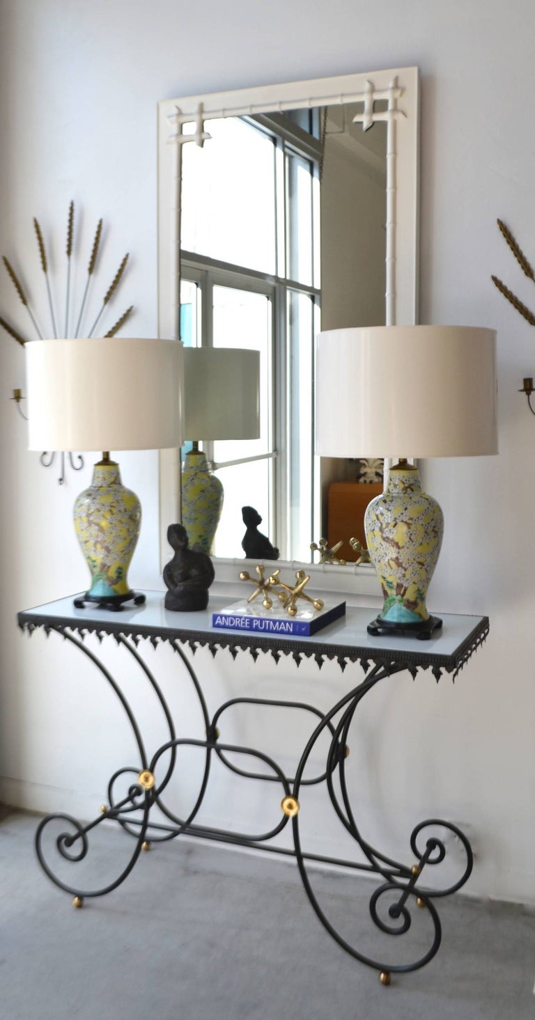 Striking pair of porcelain chinoiserie vase form polychrome table lamps, circa 1950s-1960s. These Hollywood Regency style lamps are mounted on carved ebonized wooden bases and wired with brass fittings.
Shades not included.
Measurements:
Overall: