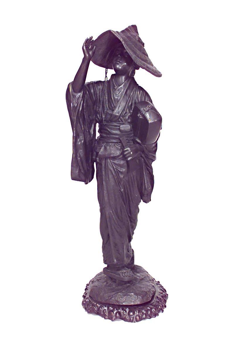 Pareja de grandes figuras de bronce de estilo asiático japonés (s. XIX) de hombre y mujer con guitarras sobre base de madera de teca perfilada.
