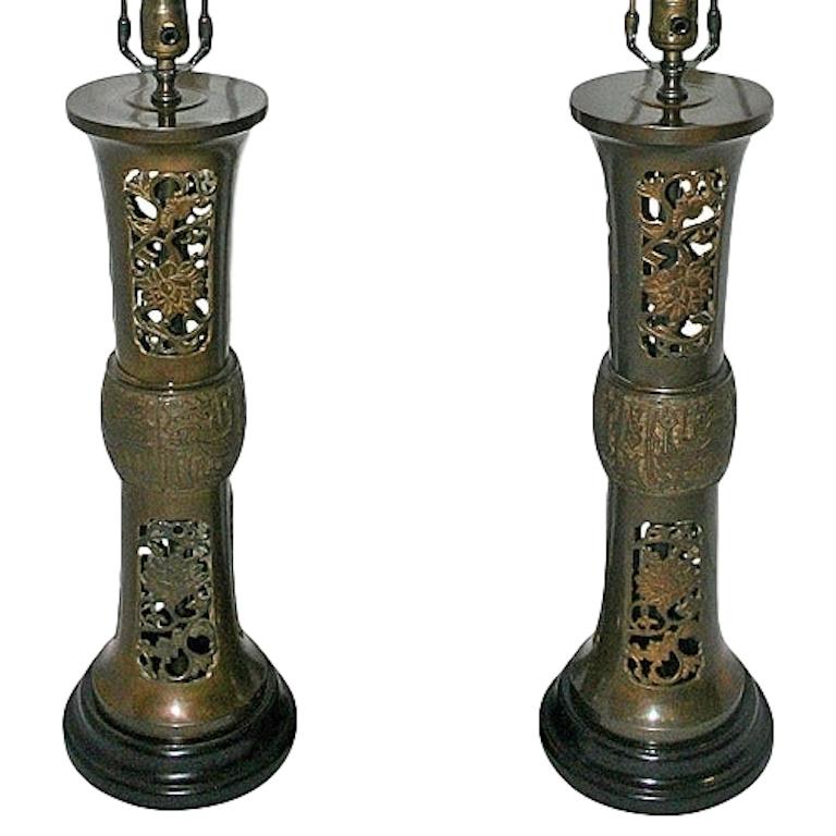 Pair of circa 1930s Chinese patinated bronze table lamps with elaborate foliage motif on a pierced body.

Measurements:
Height of body 22.5