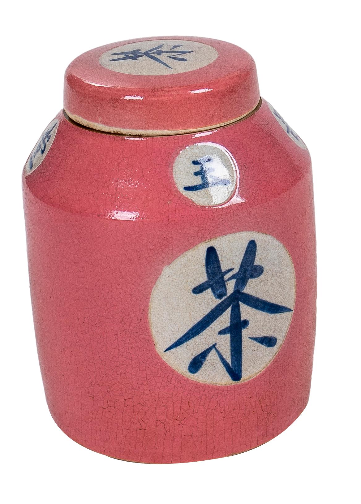 Pareja de tibores de ceramica vidriada rosada con tapa y letras chinas. Asia.