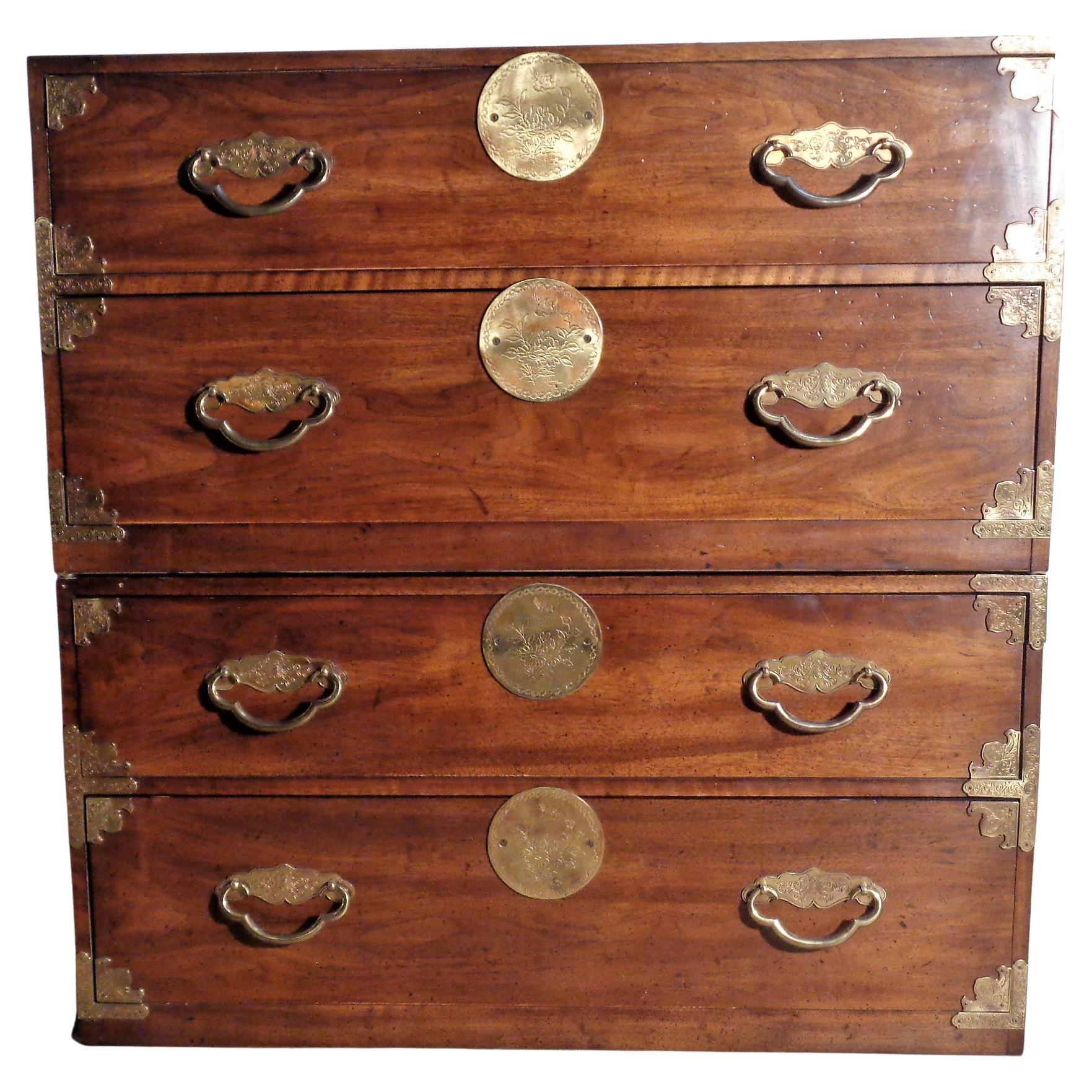 A pair of Asian style two drawer figured walnut campaign bachelor chests by Henredon Fine Furniture with decorative brass hardware at fronts and recessed brass swing handles at sides. Can be used separately as low two drawer chests ( each measuring