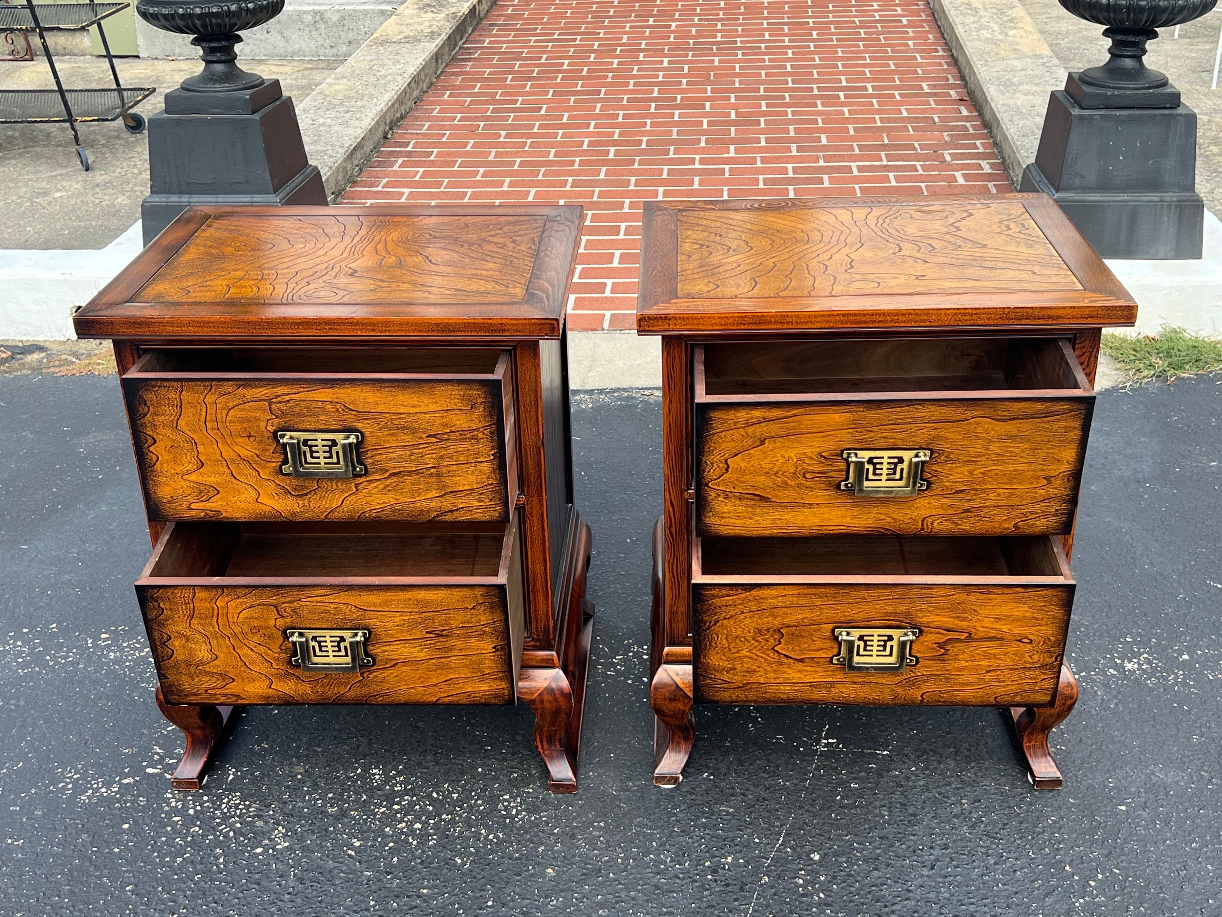 Coppia di comodini Asian Style . Comodini alti e belli, con due cassetti per un ampio spazio di archiviazione. Un design elegante con toni caldi del legno e accenti in ottone.