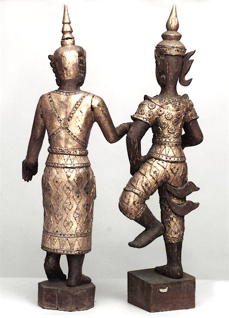 Pair of Asian Thai (19/20th Cent) carved figures with gold and jeweled glass clothes on square shaped base
