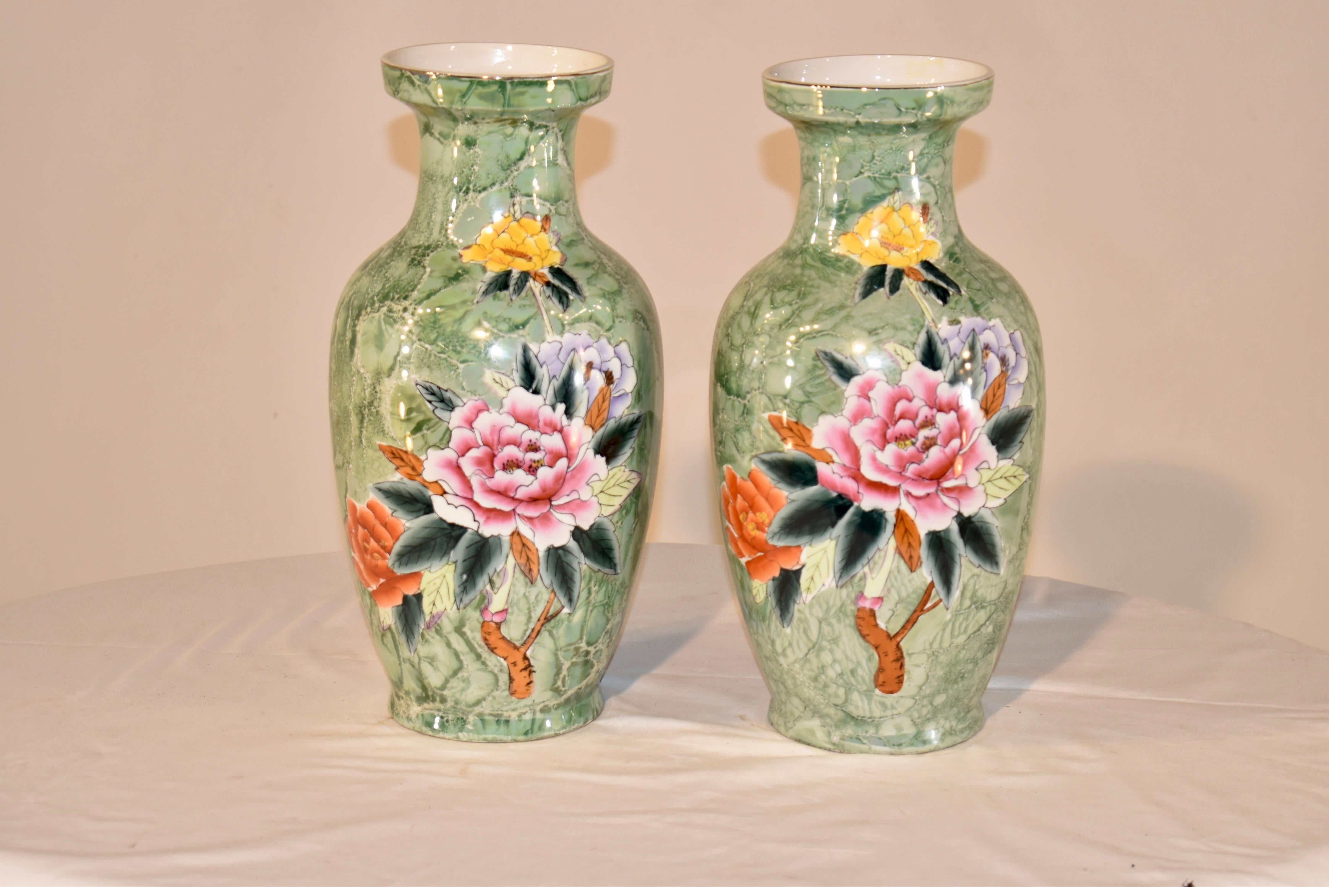 Pair of unusual large ceramic vases with wonderful shape and style.  The base color is a mottled green which is reminiscent of marble, and is hand painted with floral decorations.  They are beautiful,  and so different than anything we have had the