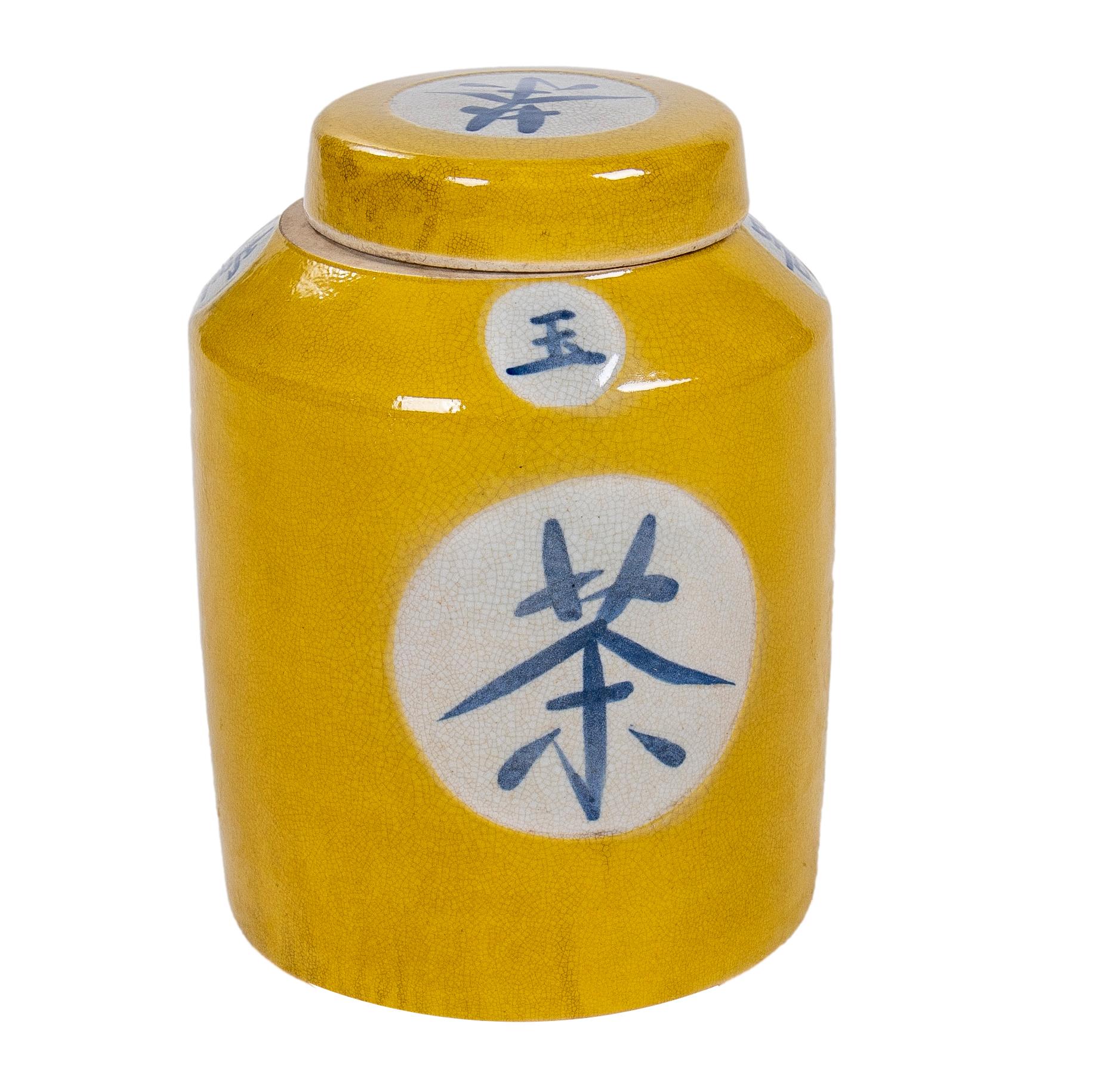 Paire d'urnes asiatiques en porcelaine émaillée jaune avec couvercles et décorées d'inscriptions chinoises.