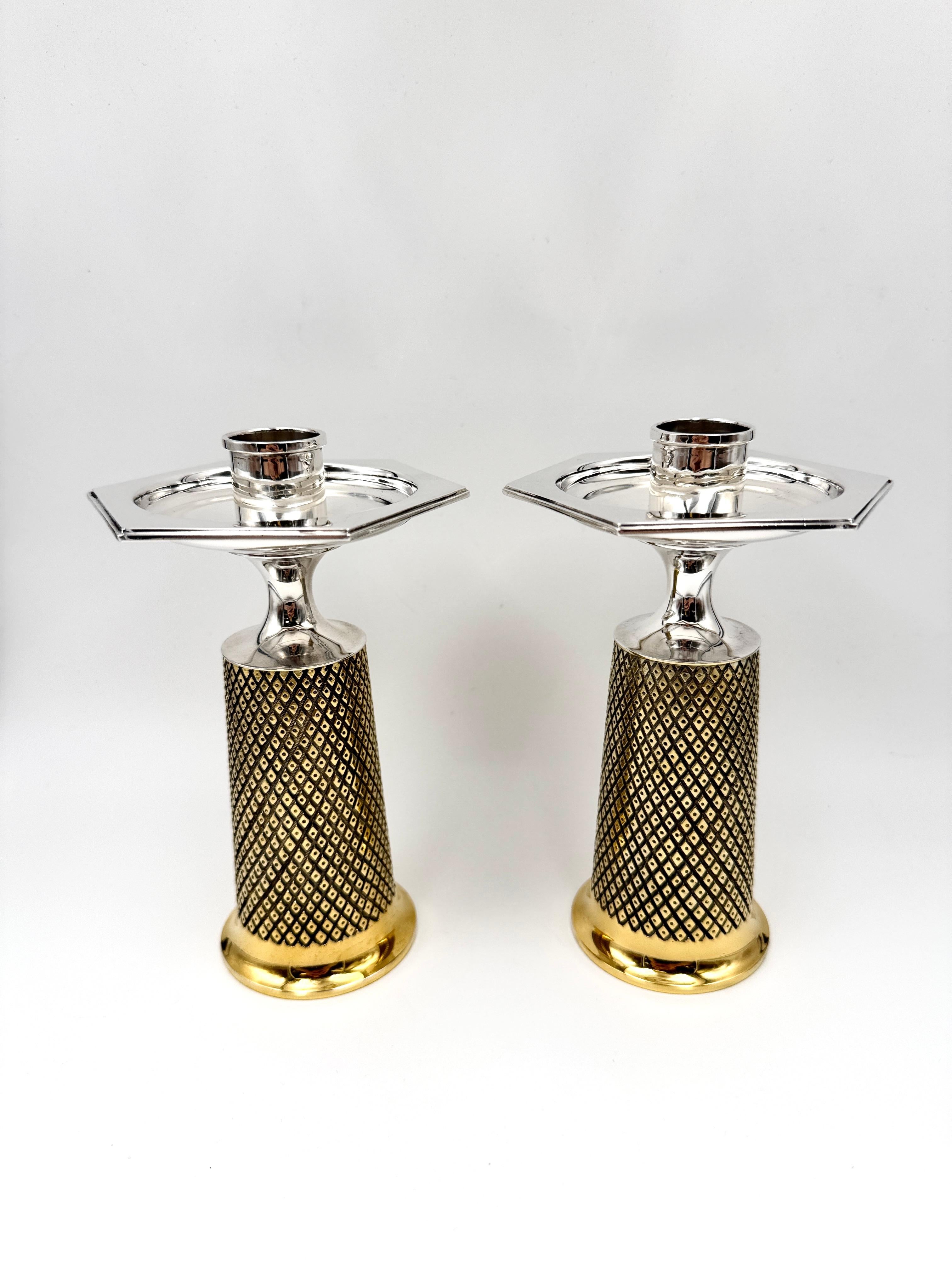 A pair of silver and gilt candlesticks by Asprey & Co., designed by Anthony Elson, London, 1970, each stamped “Designed by Anthony Elson”, of tapering circular form, the bodies with textured lozenge decoration and gilt bases, surmounted by hexagonal