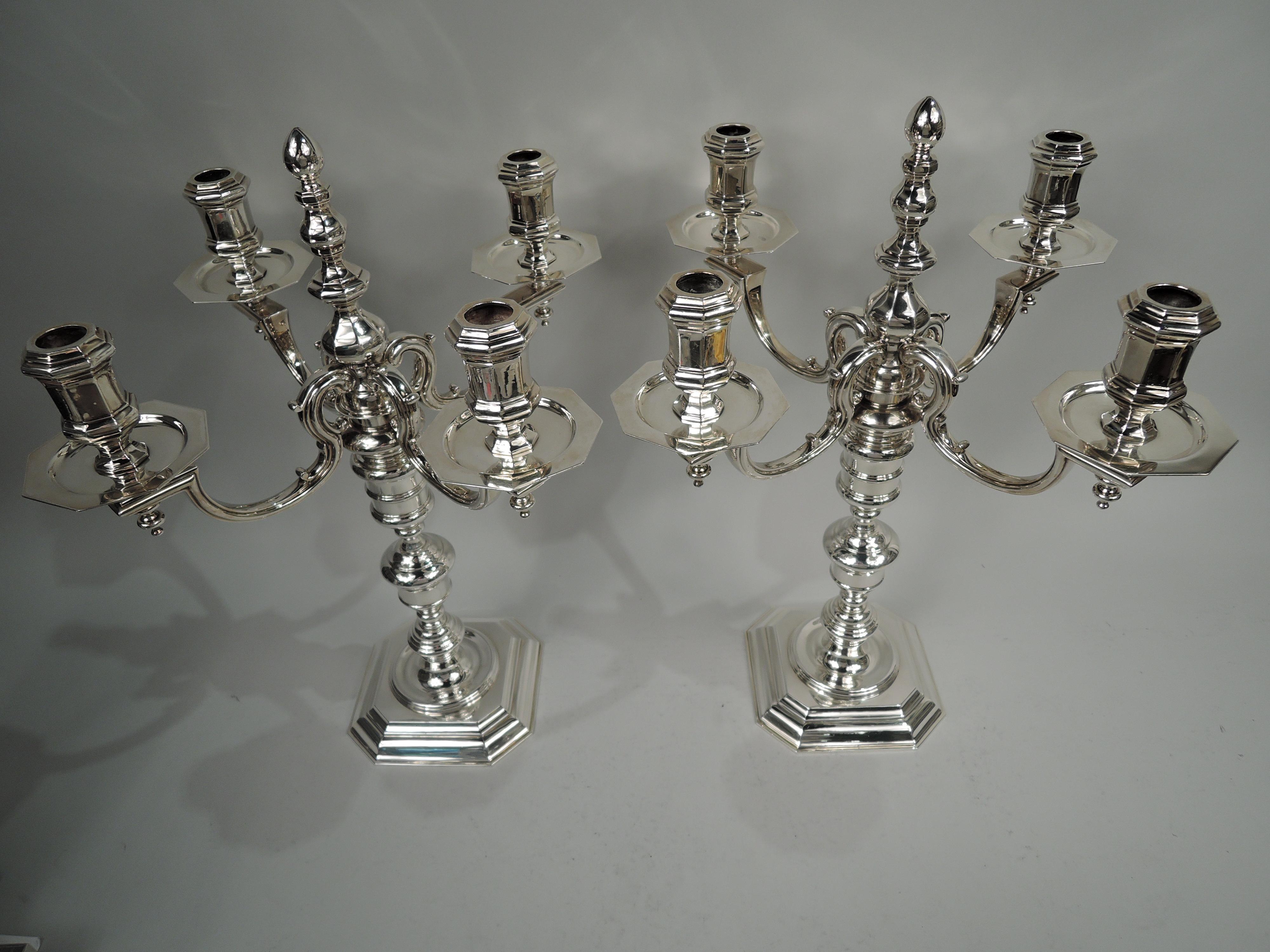 Pair of traditional Georgian sterling silver 4-light candelabra. Made by Asprey in London, 1992-3. Each: Four capped and curvilinear arms each terminating in single faceted socket with same wax pan and baluster pendant. Arms mounted to tall and