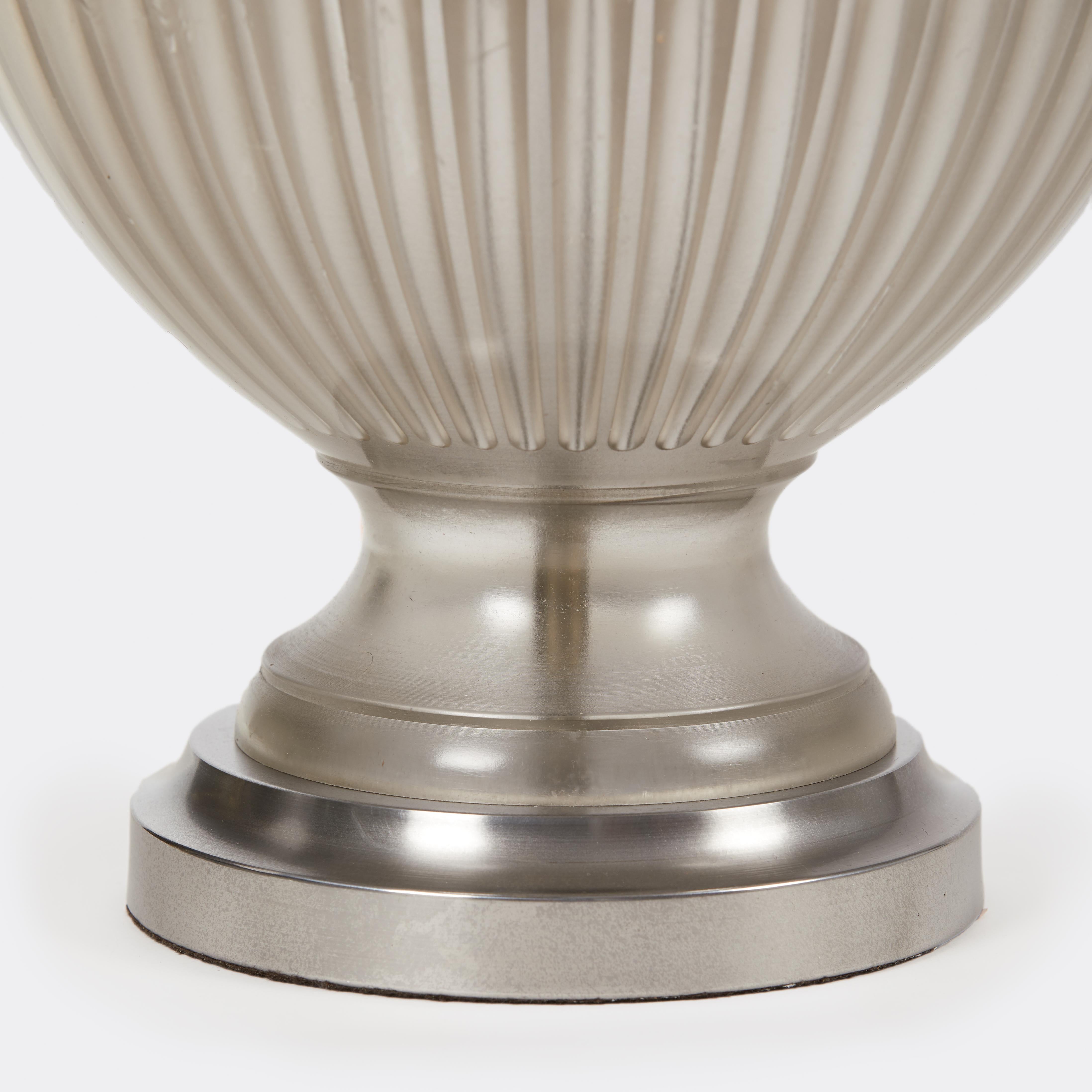 Ein Paar Lampen aus transparentem Gießharz mit glatter Außenseite und gerillter Innenseite, basierend auf dem Design einer assyrischen Vase, in der Farbvariante smoke. Jede Leuchte hat Details aus Stahl und vernickeltem Messing und zwei Fassungen.
