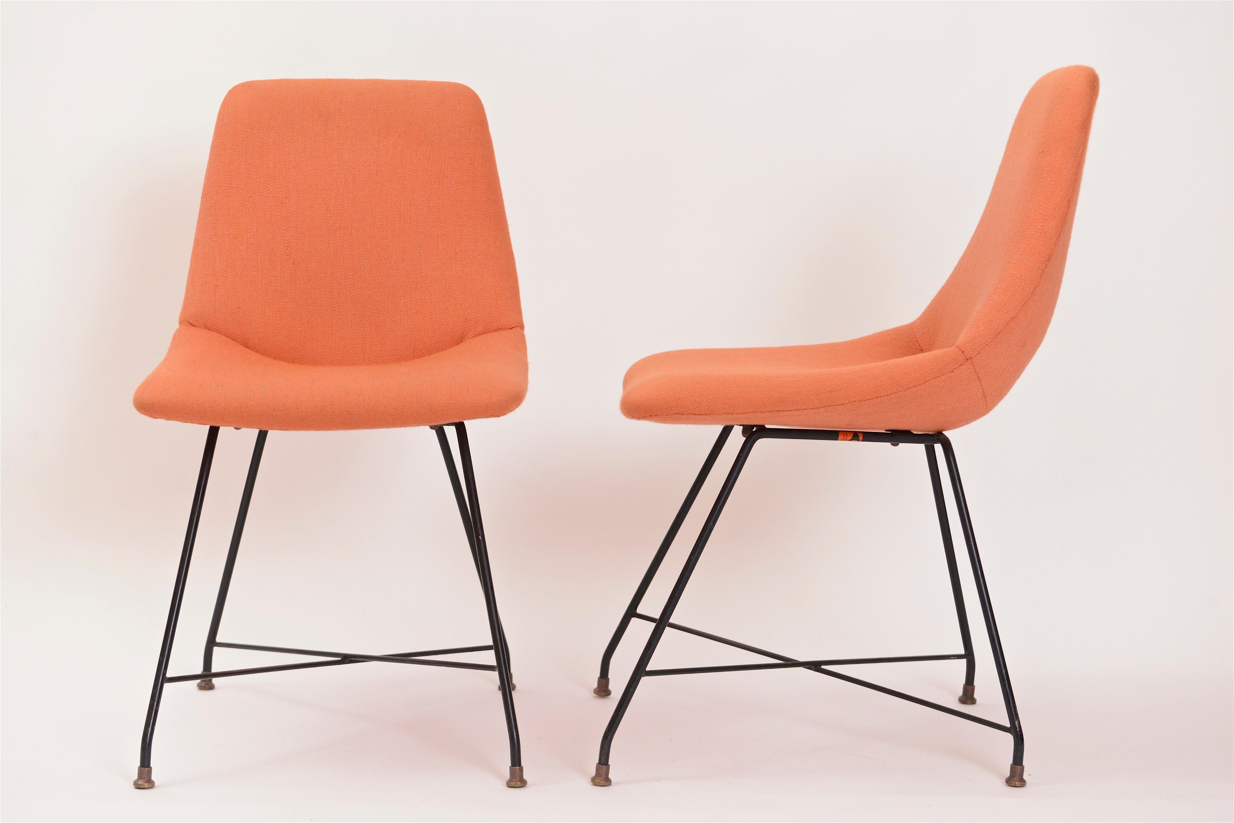 A great pair of 'Aster' chairs designed by Augusto Bozzi for Fratelli Saporiti in 1956. The chair seats, upholstered in an thick woven orange fabric, are supported by Bozzi's iconic structure of black-painted steel legs with cross stretcher and