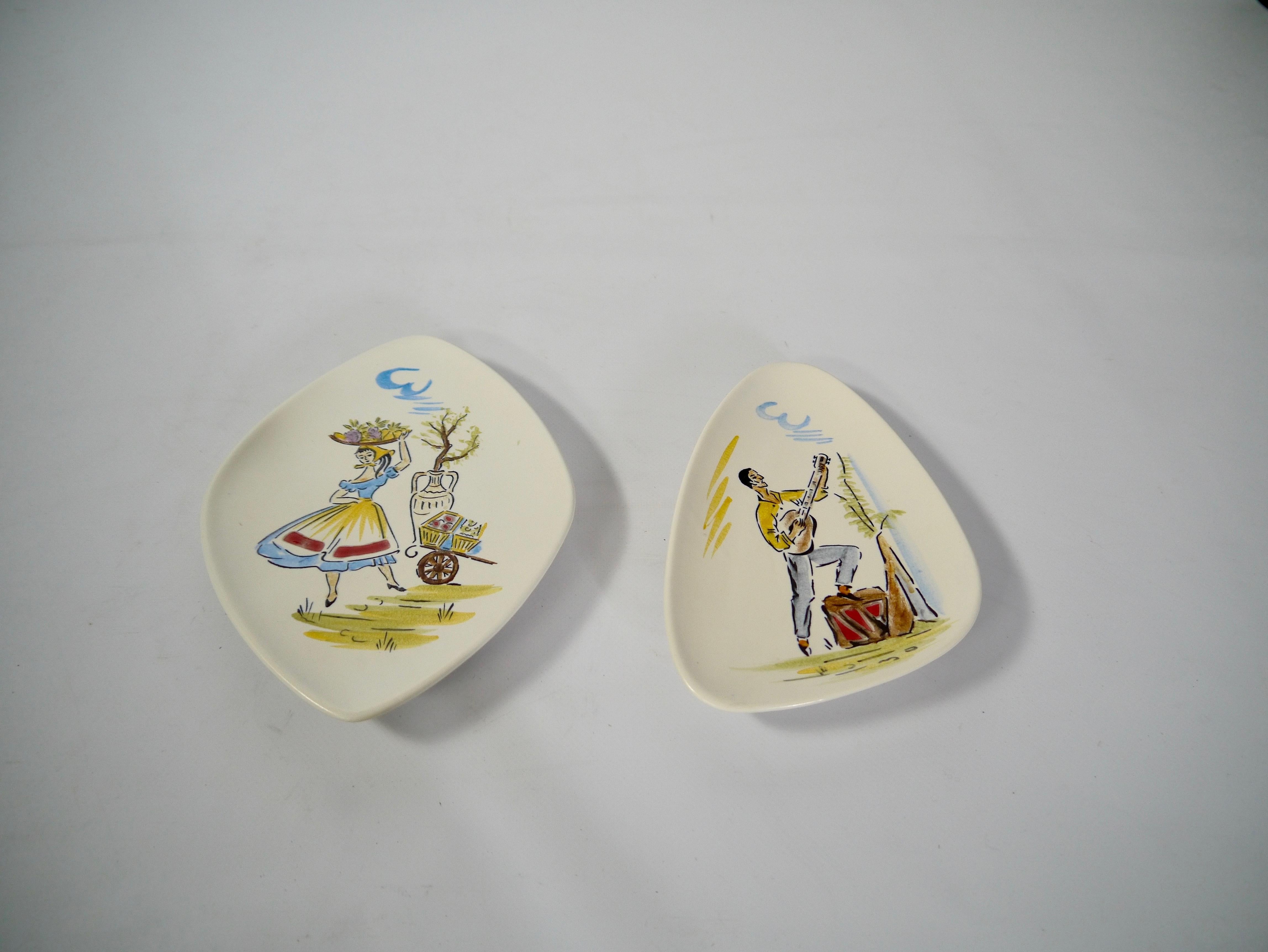 Pair of asymmetric porcelain plates, for putting over table or hung on a wall. Fabricated in West Germany in 1962. Hand-painted kitsch mediterranean mid-century drawing motifs. Marked 268 resp. 270 & Made in West Germany 1962.