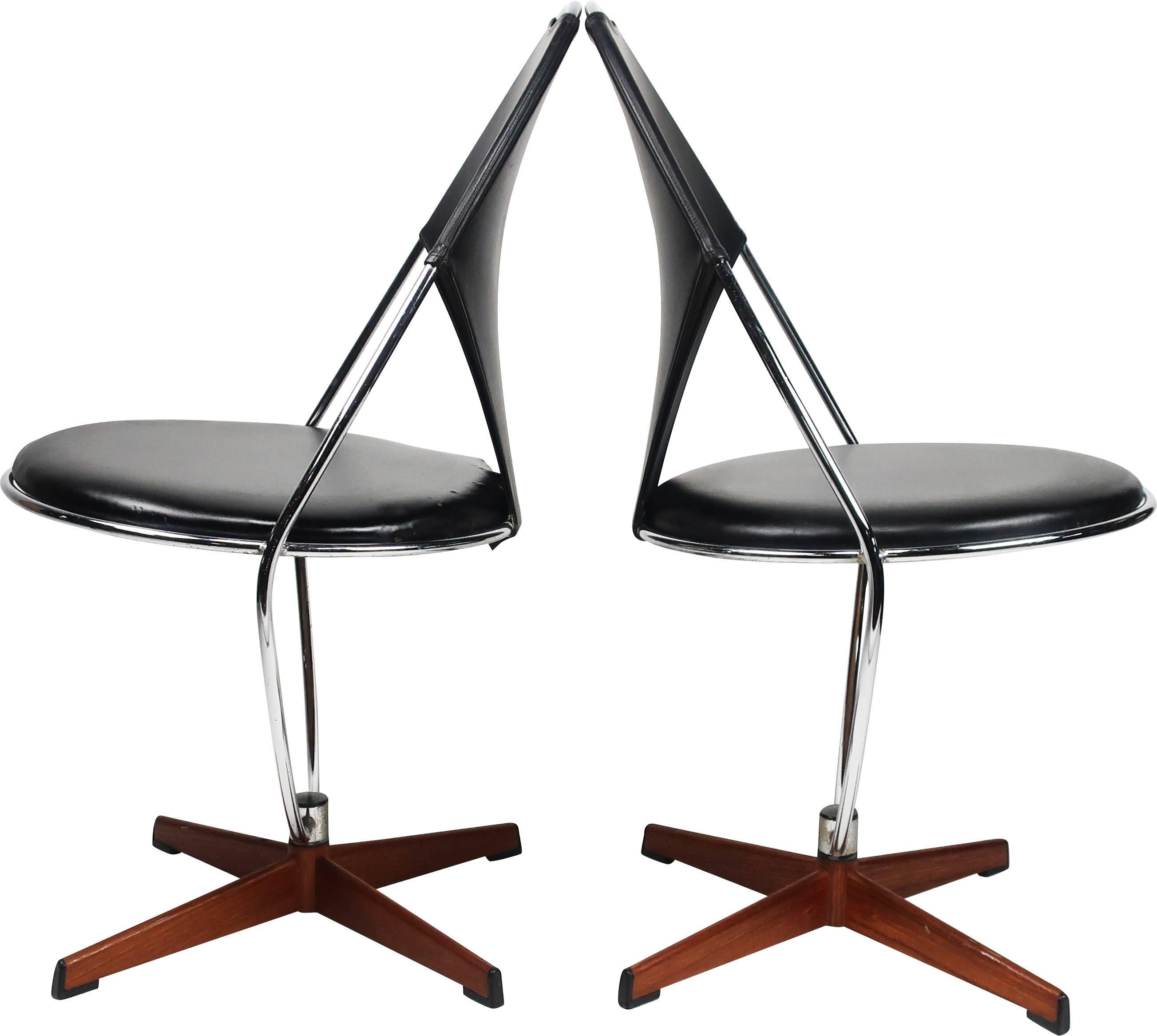A pair of perfectly Atomic Age Swedish chrome swivel chairs with curved base and seat back and detachable round vinyl cushion seat., Sits on a four legged metal base covered with teak veneer, Designed by Dahlens Dalum in Sweden in the 1950s, these
