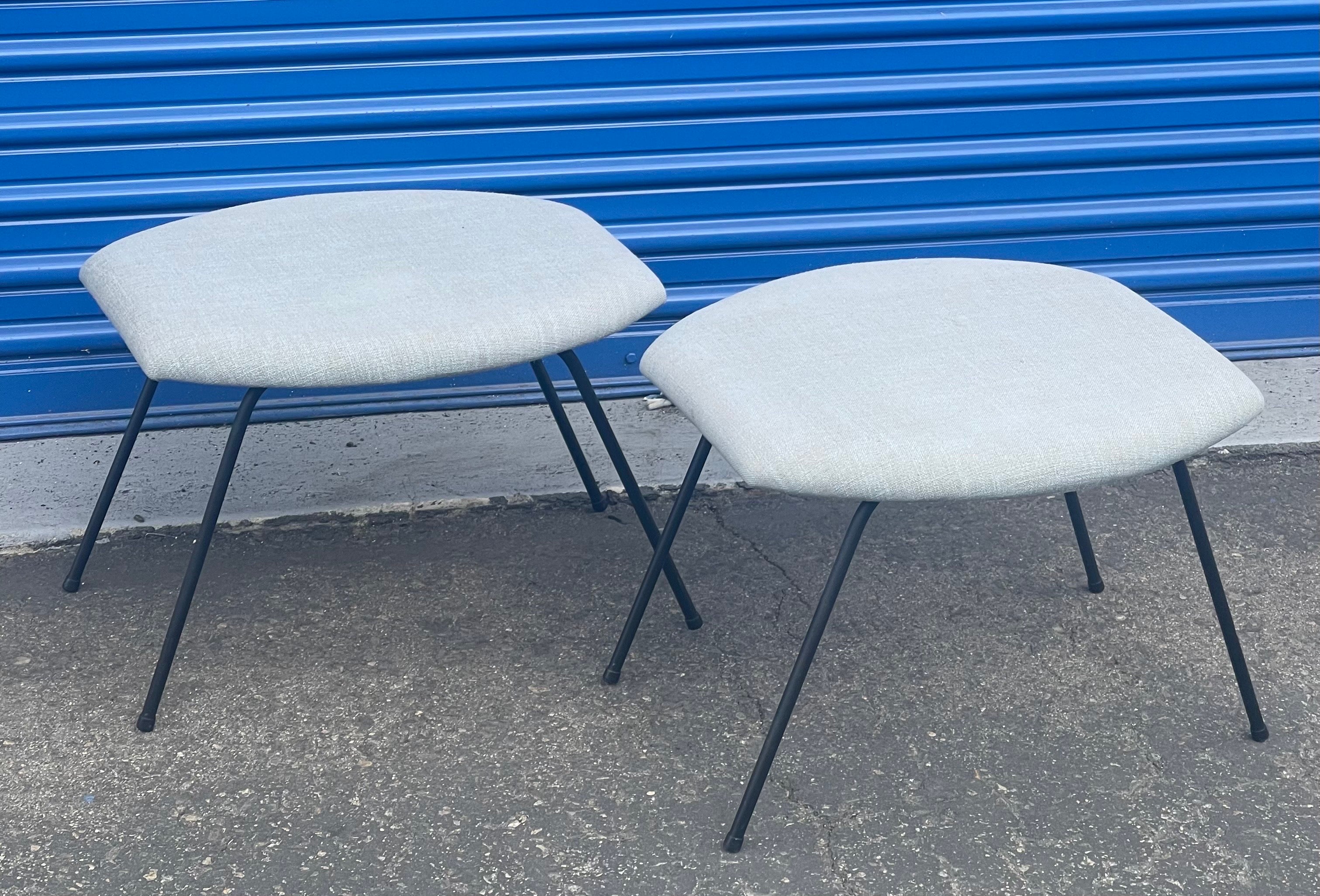 Pair of atomic age iron base ottomans / benches by Joseph Cicchelli, circa 1950s. Great California design on this pair of freshly reupholstered ottomans / stools /benches with linen fabric. The legs are solid iron pipping and have been resprayed in