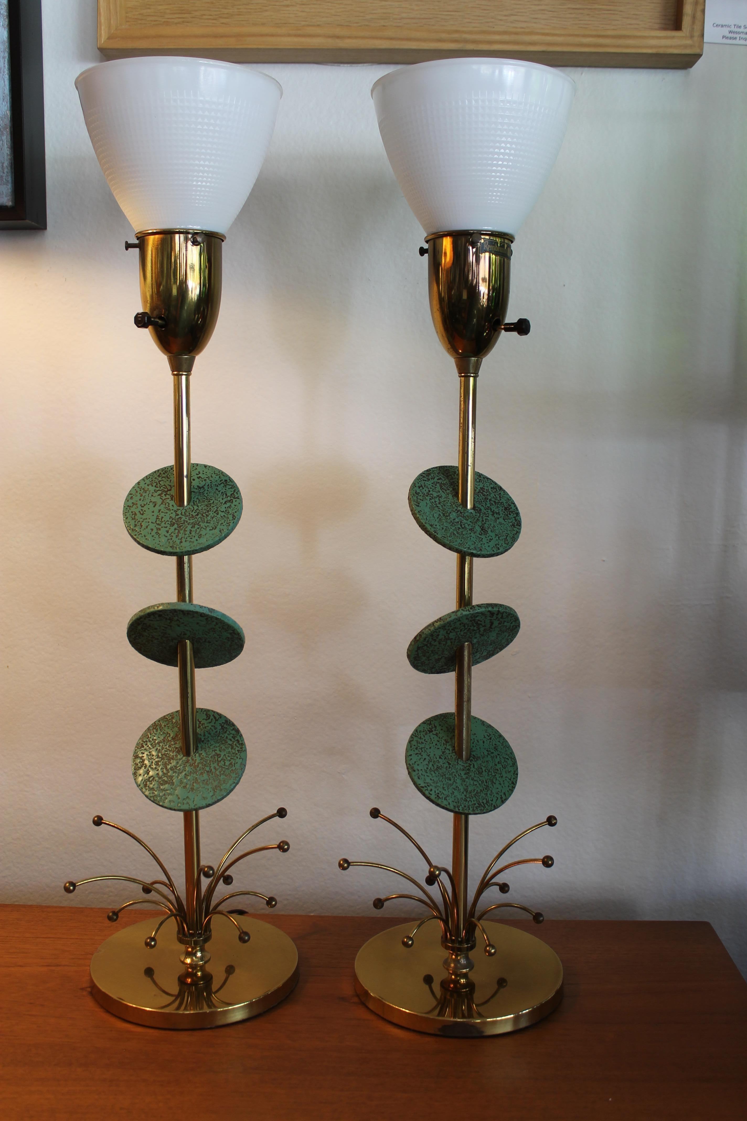 Pair of atomic Rembrandt Masterpiece lamps. Each lamp has 3 painted wood discs. Each lamp measures 27.5