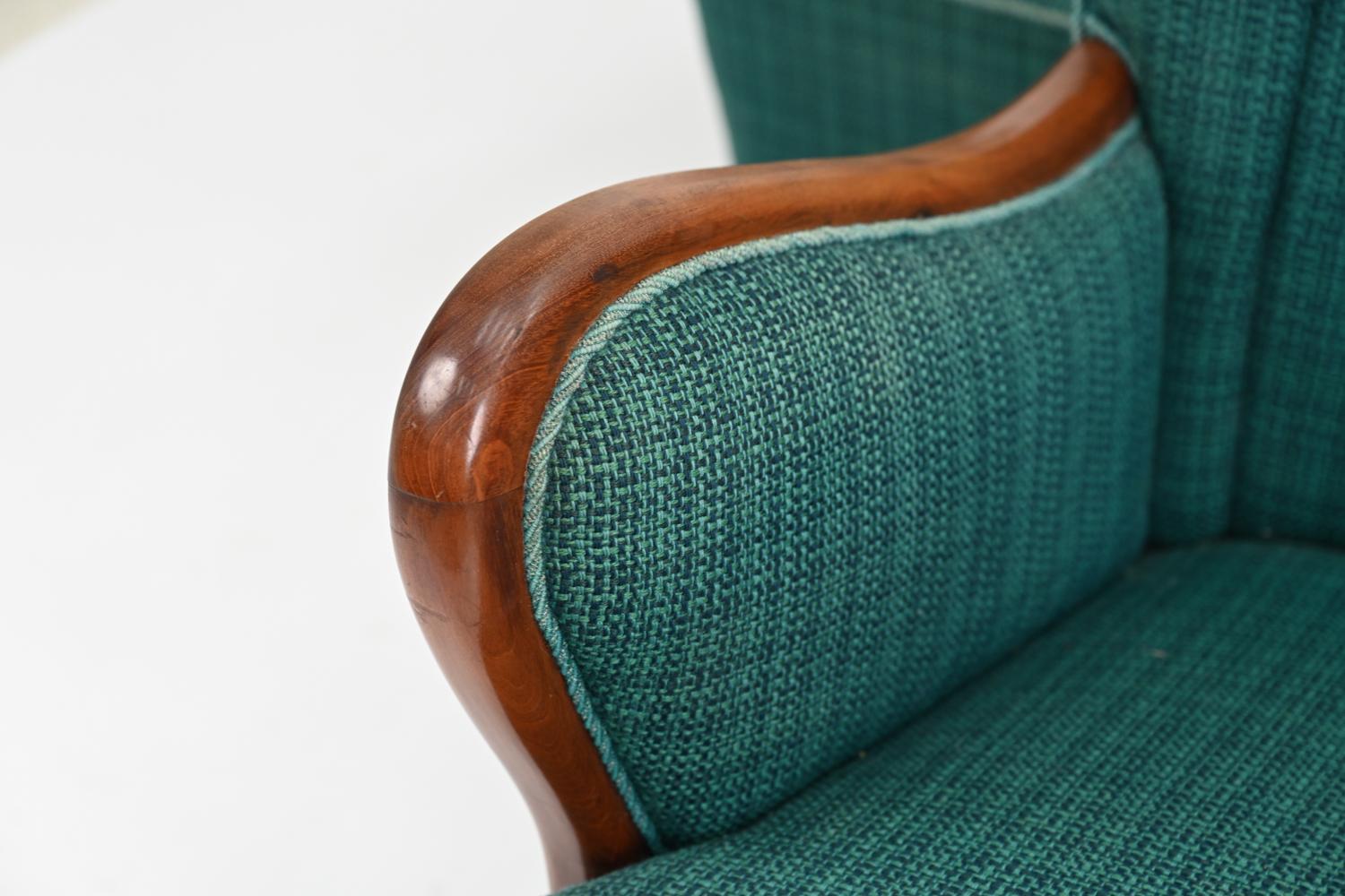 A handsome and comfortable pair of Danish Art Deco period easy chairs attributed to Otto Faerge, of quality design and construction. Featuring mahogany frames with flared arms, a slight wingback design, and ribbed teal wool upholstery. No apparent