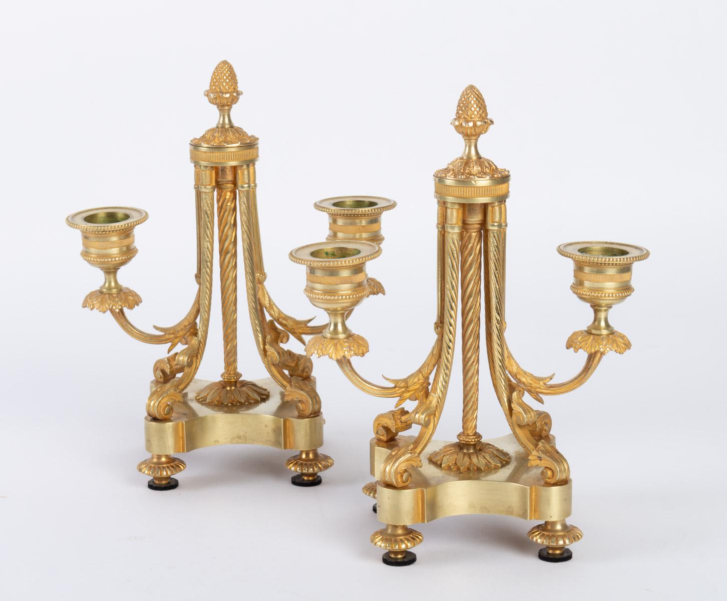 Pair of atypically shaped two-light candleholders. Neoclassical decoration inspired by the Louis XVI period. Gilded bronze, circa 1880.

Measures: H 21 cm, W 16 cm, D 9 cm.
