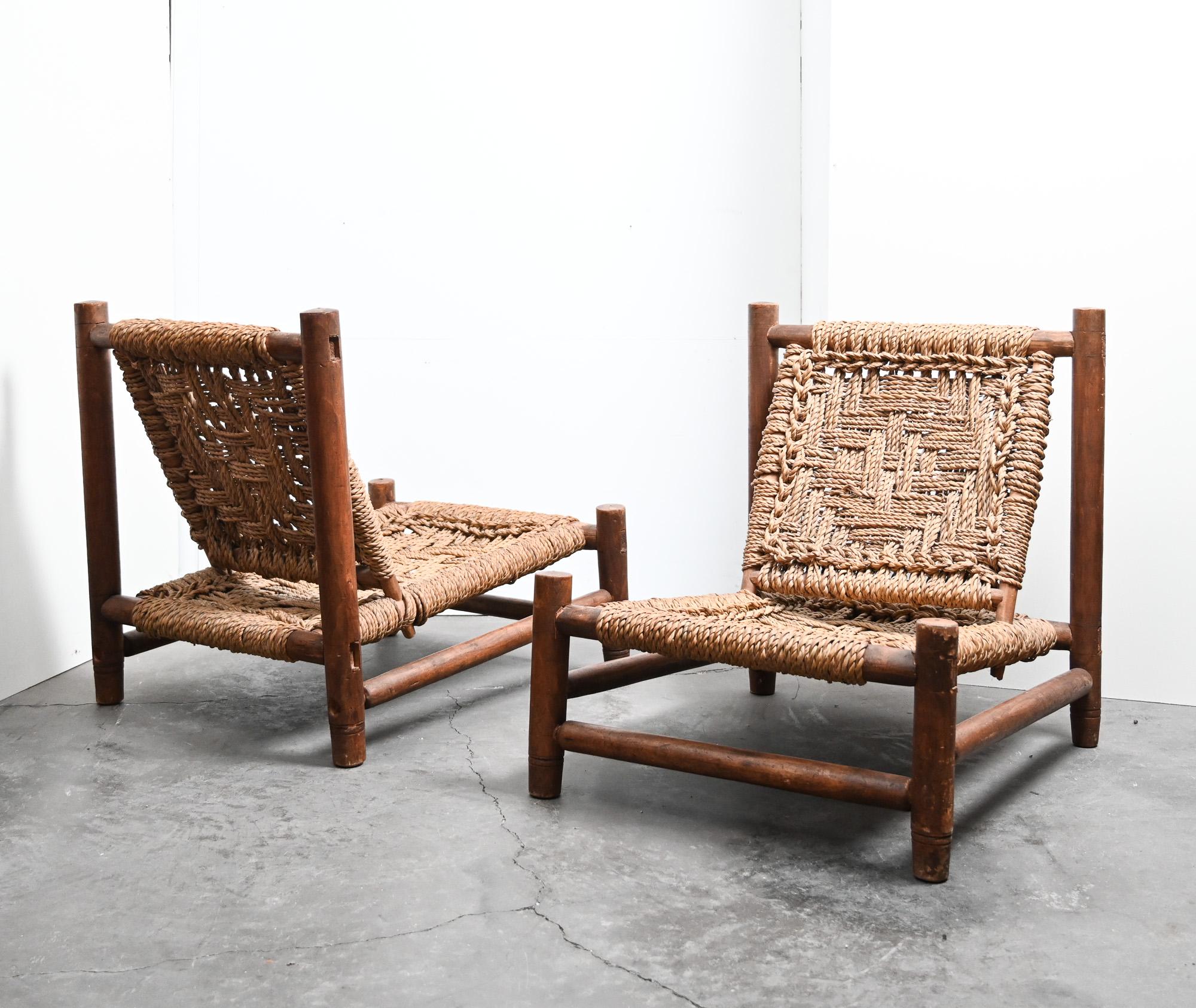 Ein seltenes französisches Paar niedriger Audoux-Minet-Stühle aus der Mitte des Jahrhunderts mit robusten Rahmen aus gebeizter Buche und wunderschön handgeflochtenen Seilsitzen und -lehnen mit dem typischen Audoux-Minet-Muster. Die warme Patina und