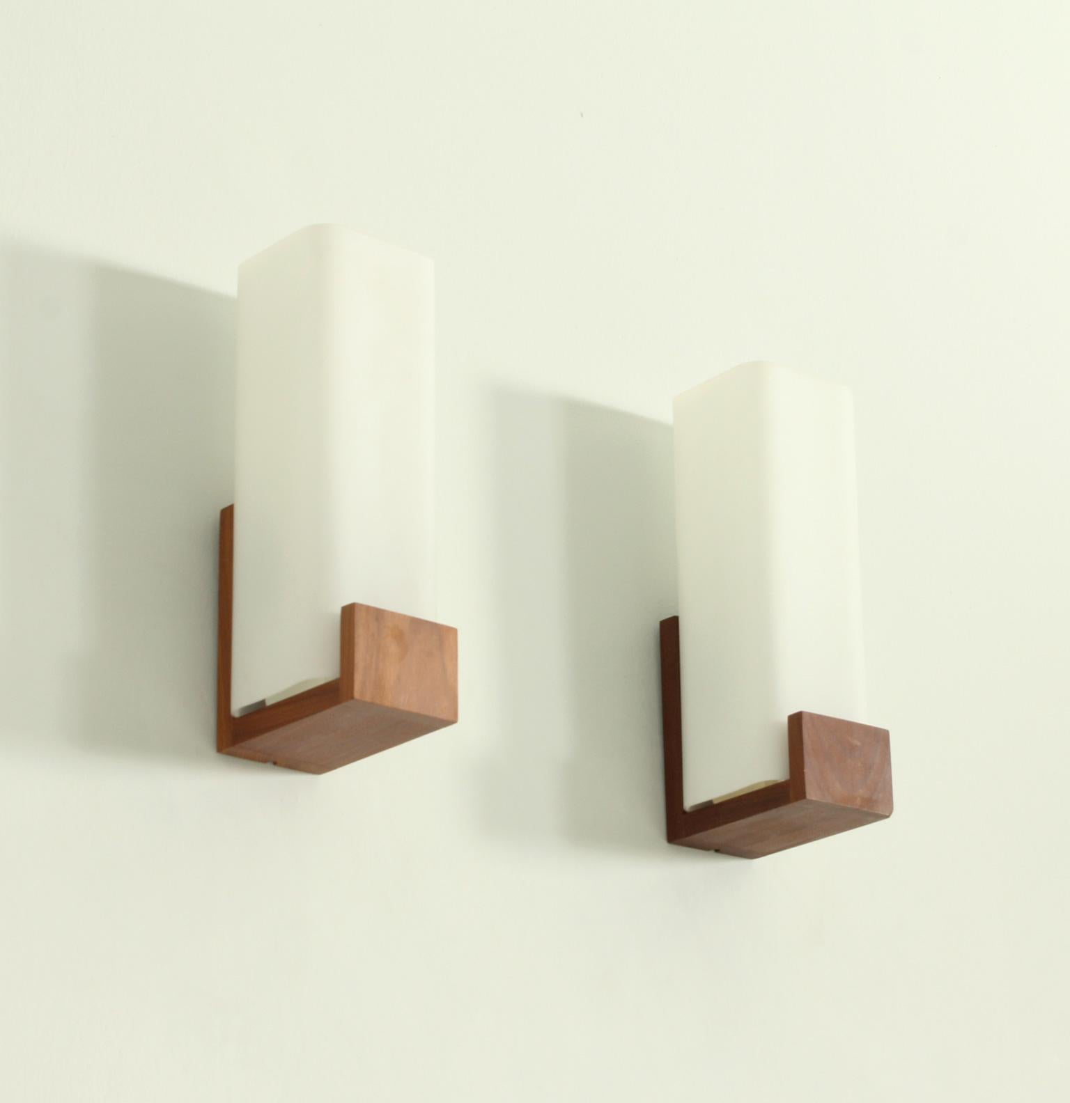 Pair of Auray 80.030 sconces designed in 1960's by Louis Kalff for Phillips, The Netherlands. Opaline glass in matt white and teak base.