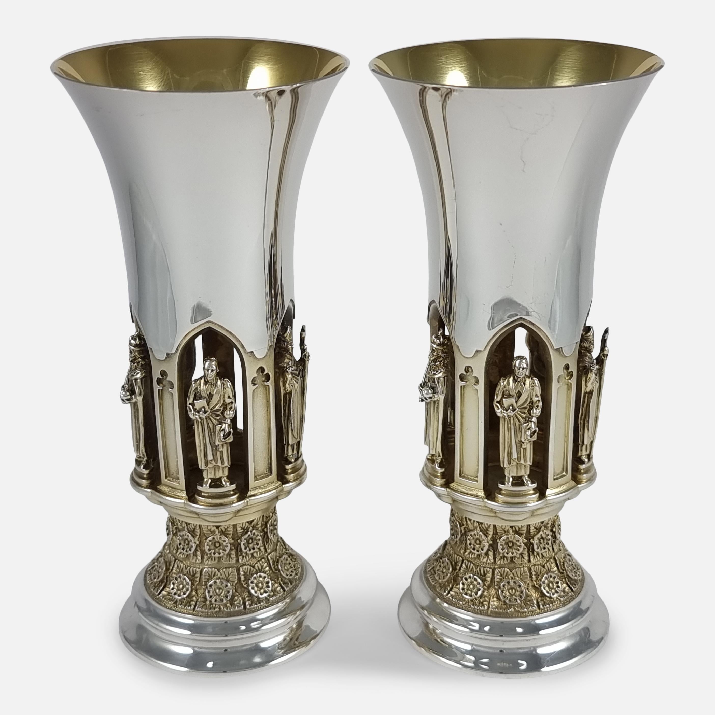A pair of Parcel-Gilt sterling silver goblets, by Hector Miller for Aurum, London, 1985. The goblets are numbered 246, and 247, from a limited edition of 500. The goblets are each crafted with a trumpet shaped bowl above a pierced gilded gallery