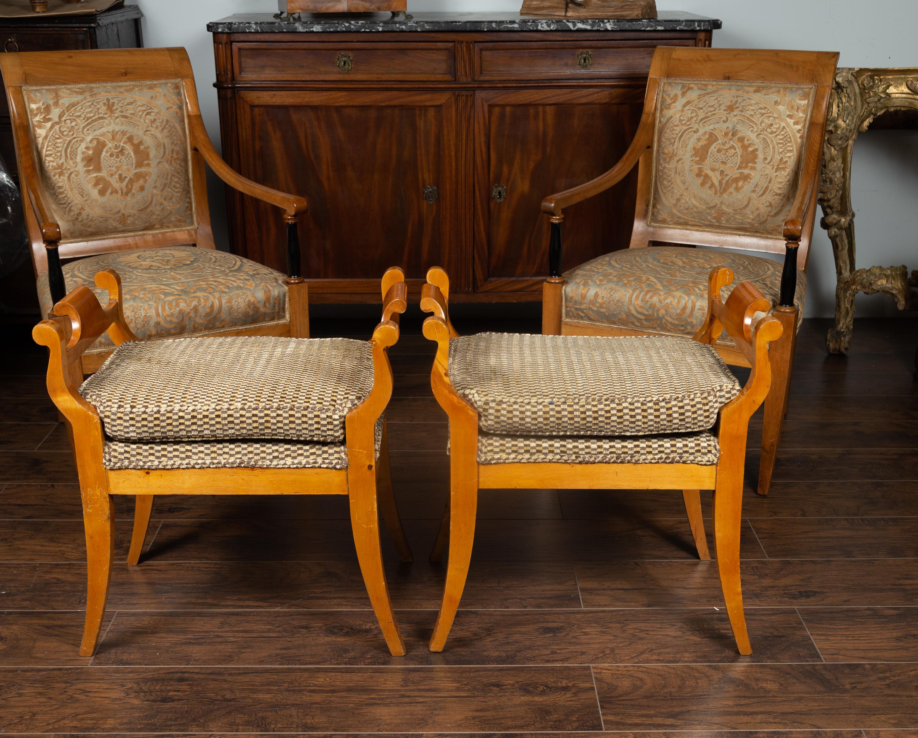 A pair of Austrian Biedermeier style wooden benches from the late 19th century, with scrolling supports, saber legs and upholstery. Born in Austria during the later years of the 19th century, each of these Biedermeier benches draws us in with its