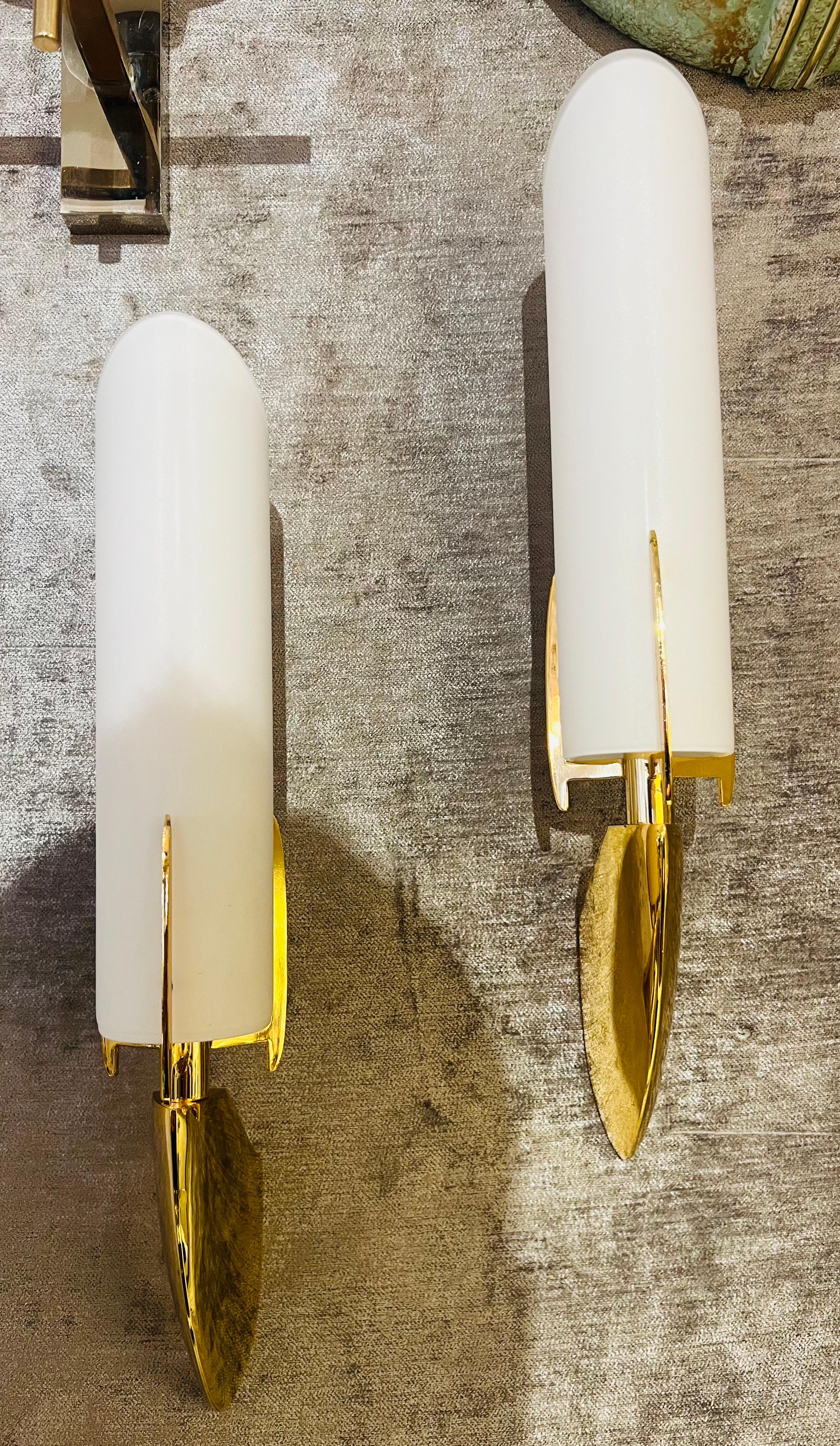 A pair of luxurious 1990s gold plated wall lights with white cylinder shades. Rewired.Made by the Austrian lighomaler, Kolarz. Original Label. Great condition, never installed.
