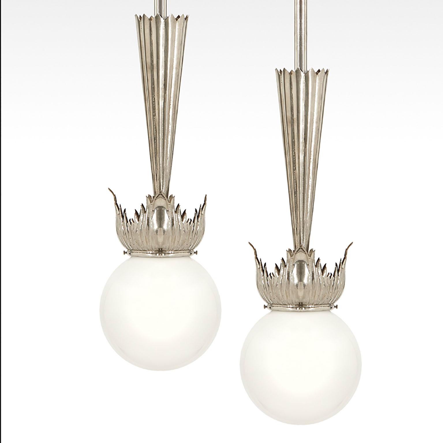 These excellent and elegant pair of Austrian Art Deco Pendant lamps have been designed by school of Dagobert Peche in Vienna, around 1925. 
They feature excellent handcrafted nickel plated brass parts with opaline glass ball shades.
 
At the