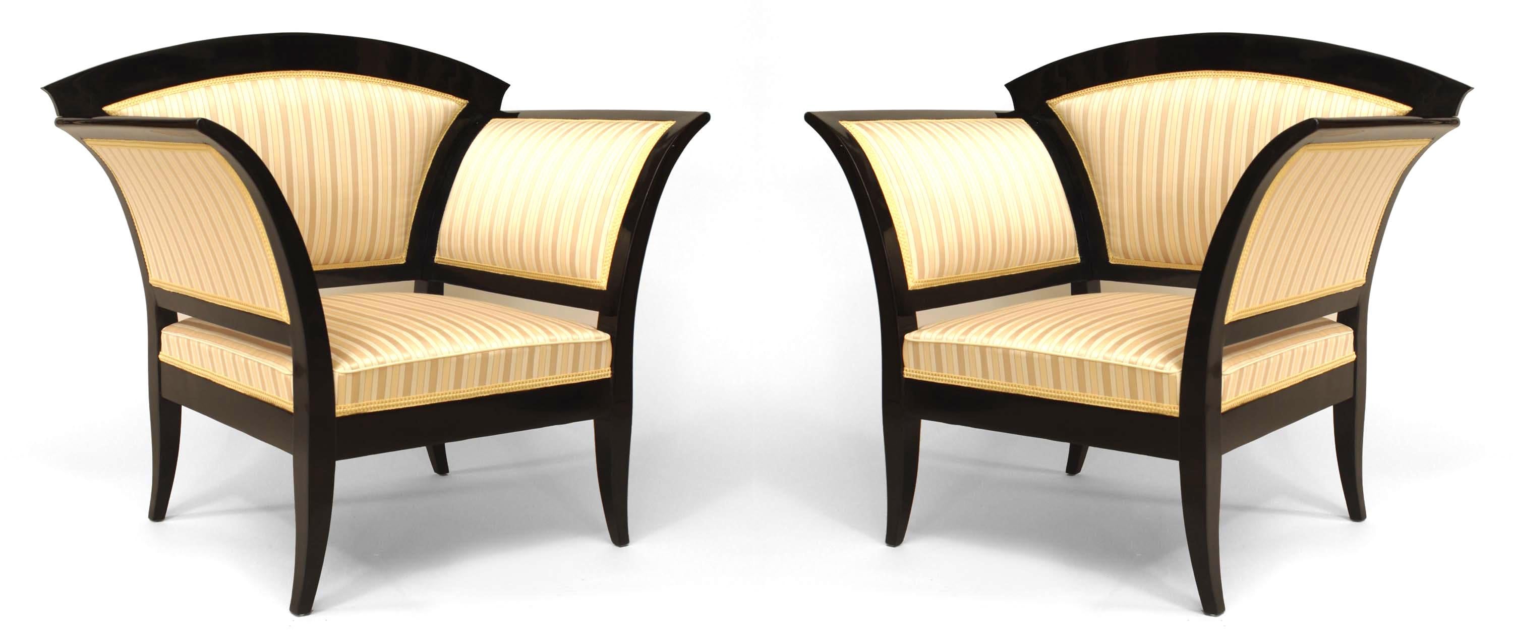 PAIR of Austrian Biedermeier ebonized cherrywood bergere chairs with flared design arms and legs with an arch form back and upholstered in a gold stripe damask (Circa 1830).
