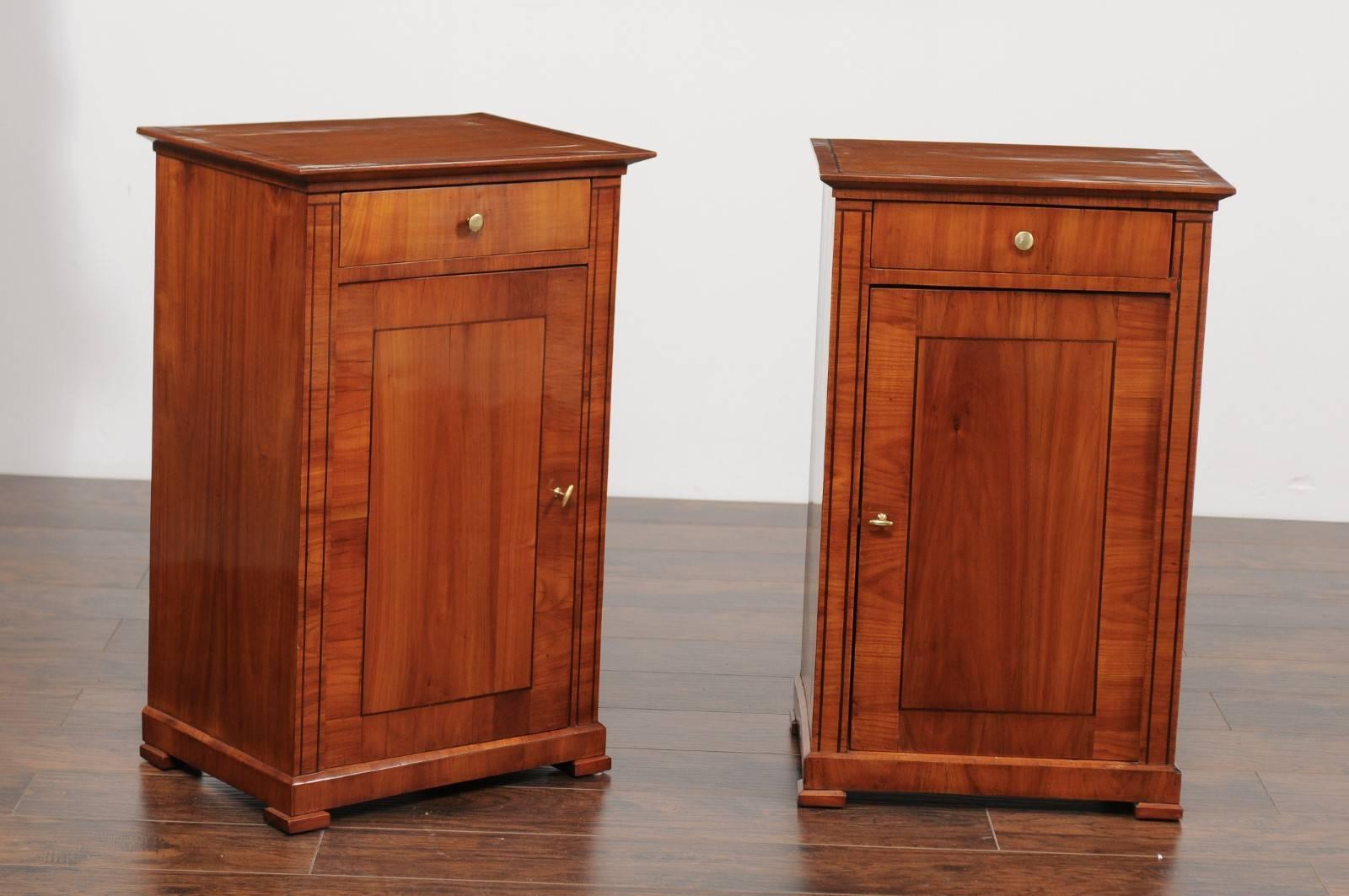 A pair of Austrian Biedermeier style walnut veneered cabinets with banded inlay from the second half of the 19th century. Each of this pair of Biedermeier stands features a rectangular top adorned with a thin banded inlay of darker color, sitting