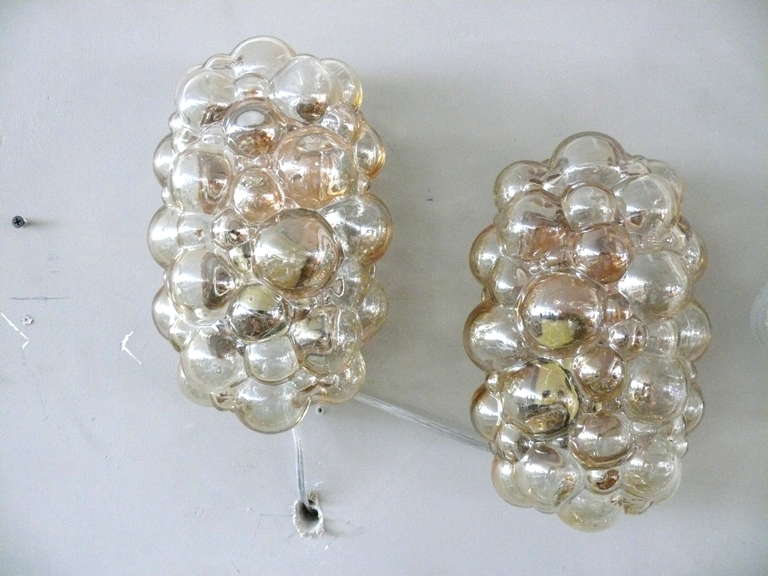 Beautiful pair of ovular Austrian bubble glass sconces with brass hardware. Amber colored glass. Professionally rewired.