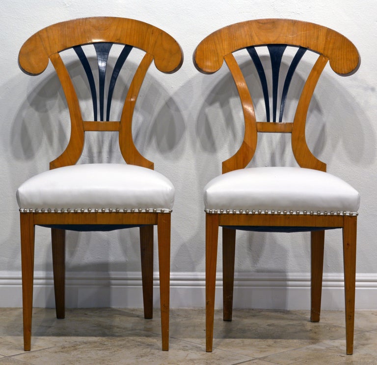 These Austrian salon or side chairs date to the mid 19th century and are great examples of the Biedermeier style. The focal point is the ebonized fan-shape splat surmounted by a boldly arched top-rail. The seats are recently reupholstered and