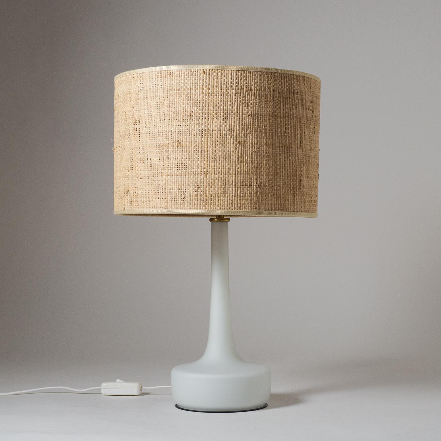 Pair of Austrian table lamps from the 1960s. Blown glass base with a white inner casing and satin finish on the outside and a large raffia shade with brass details. Two original brass E27 sockets.