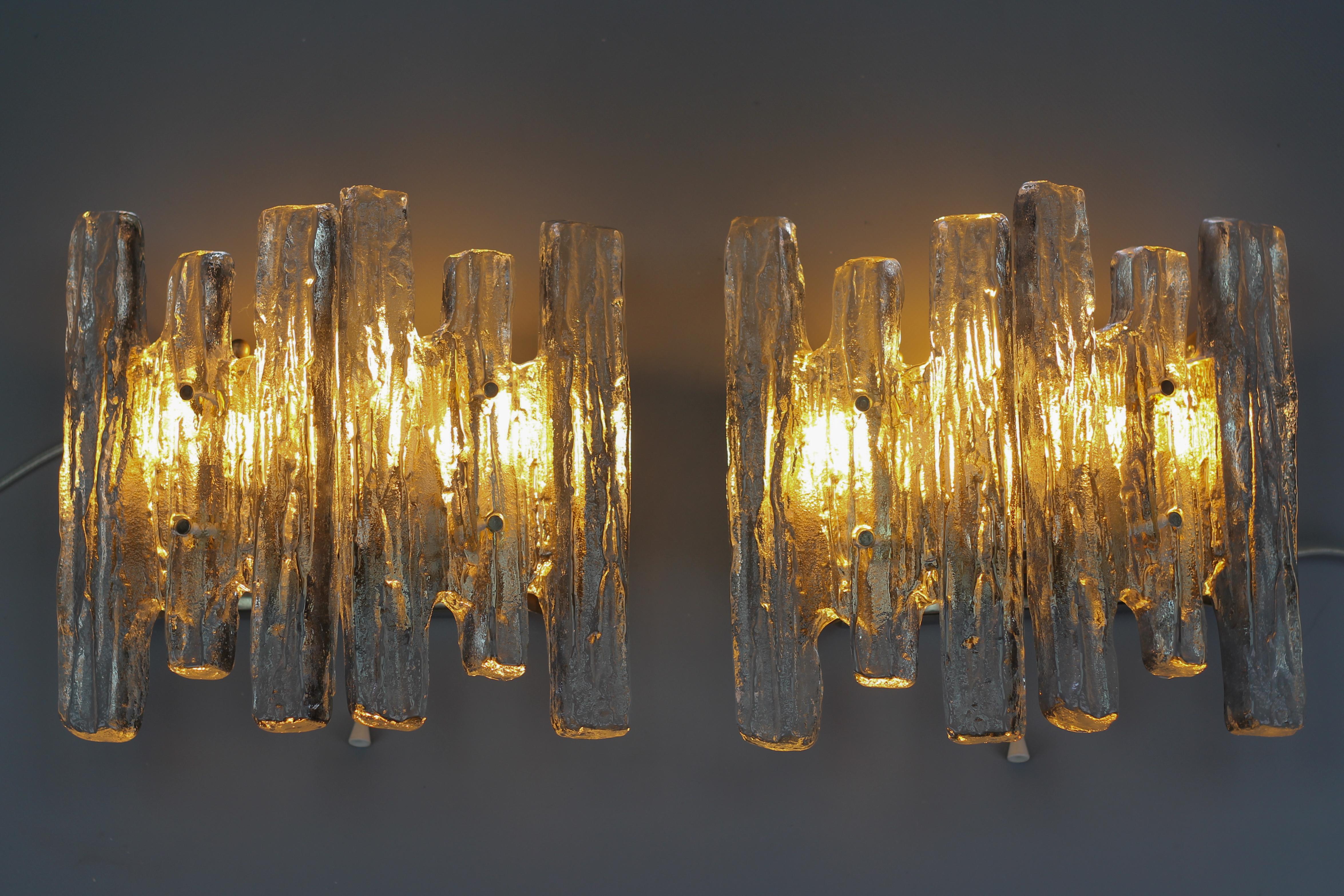 Ein beeindruckendes Paar moderner Wandleuchter aus Eiszapfen-Eisglas von Kalmar, Franken KG, Österreich, etwa in den 1970er Jahren.
Wunderschöne und elegante Wandleuchten mit jeweils zwei schweren Eisglasblöcken, vernickelter Stahlrückwand mit drei