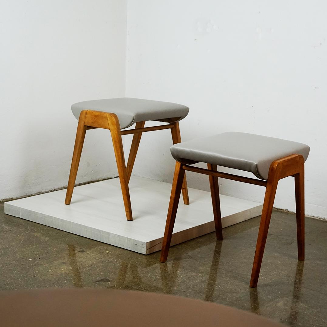 This Pair of Austrian mid century vintage beechwood and renewed grey leather stools were designed by Franz Schuster and produced by Wiesner Hager in Vienna. 
They feature a beech wood frame and seats covered with renewed grey Leather, so they are in