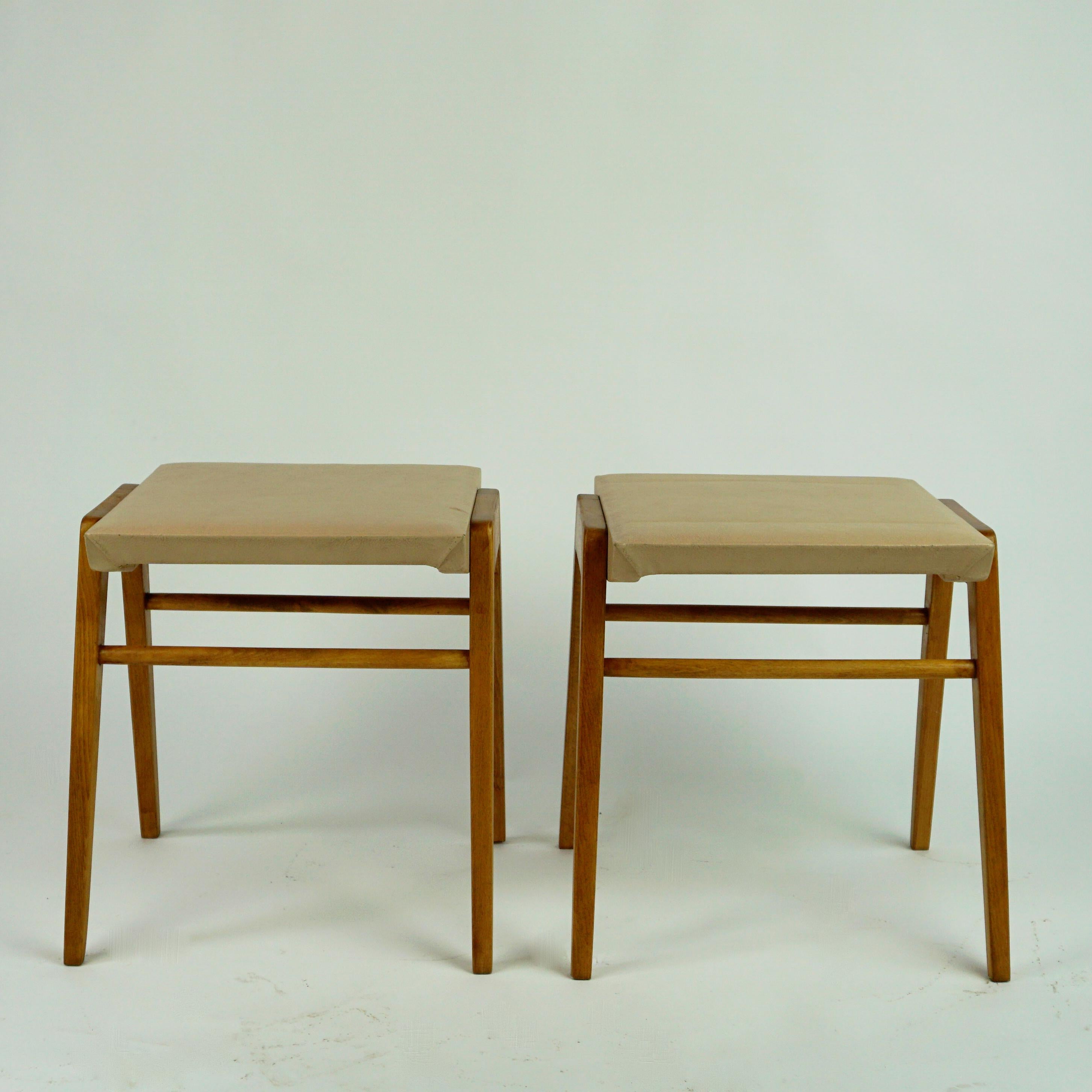 This Pair of Austrian mid-century vintage beechwood and faux leather stools seem to be designed by Roland Rainer and produced by Emil and Alfred Pollak in Vienna as they are very similar to the famous Wiener Stadthallenstuhl by this very imortant