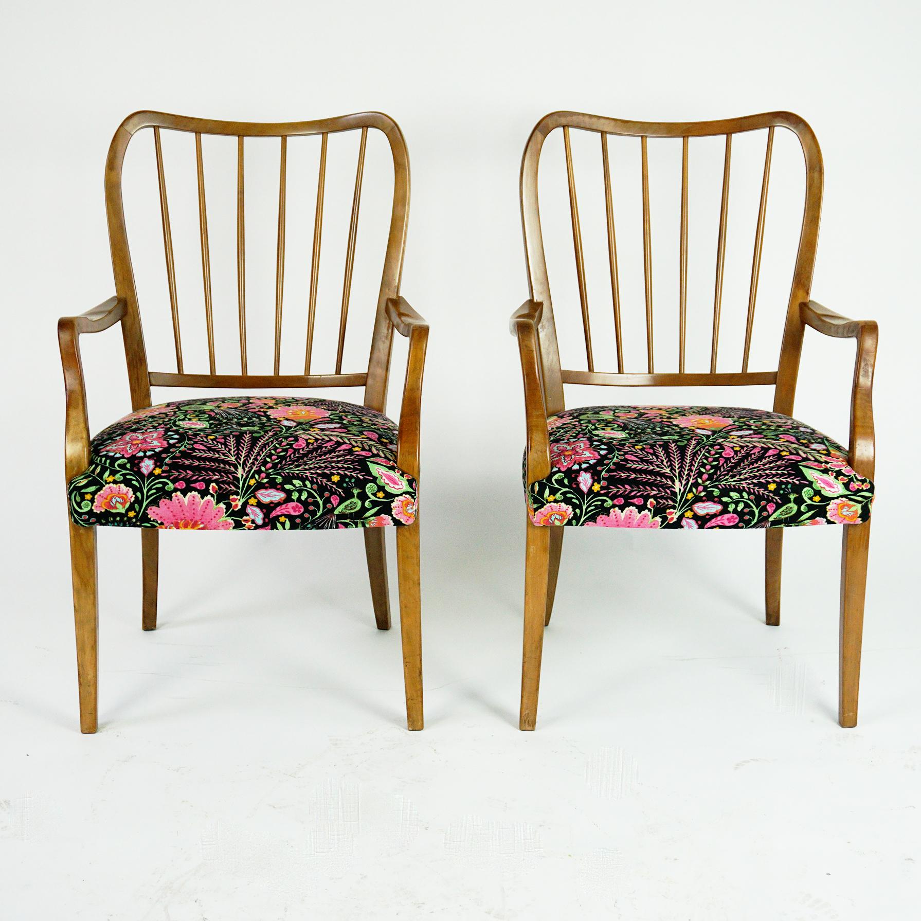 This elegant and comfortable pair of dining armchairs was designed by the Austrian architect and designer Oswald Haerdtl and manufactured in the 1950s in Vienna. 
The sculpted Chairs are made of Walnut and have seats with renewed Flower fabric.