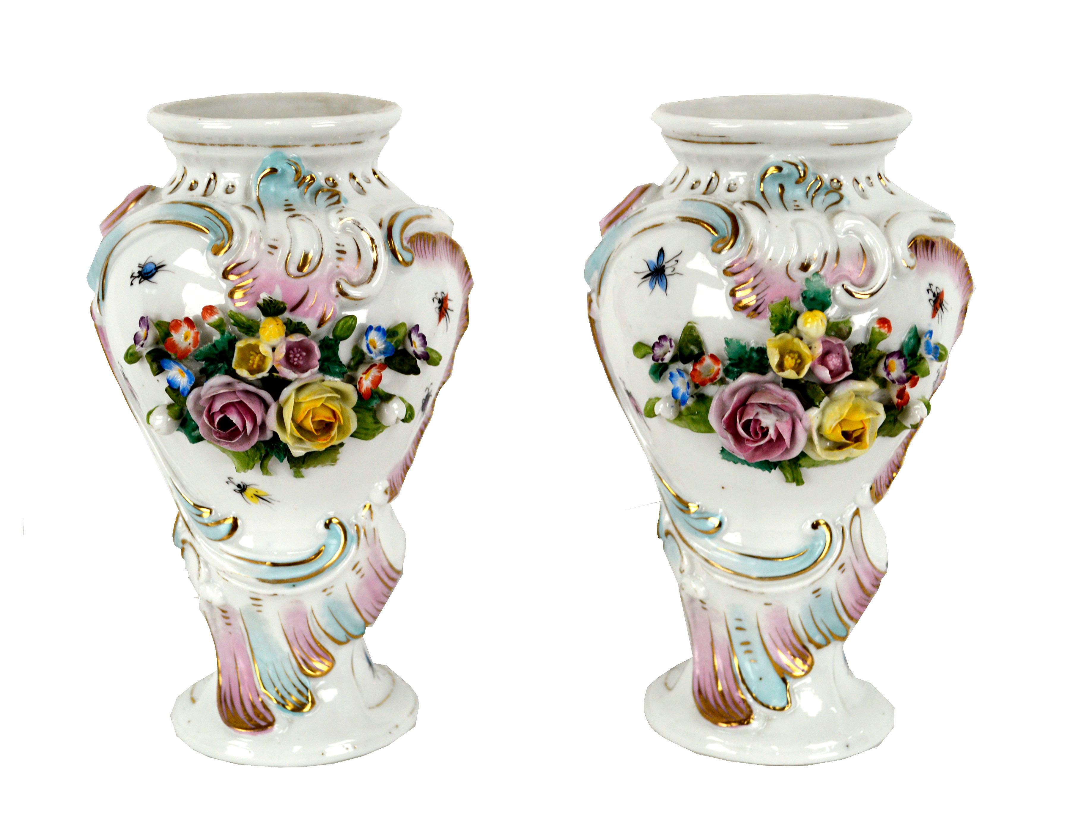 Pair of exquisite 19th century Royal Vienna porcelain vases. A fine example of the Neo-Classical Austrian style, these vases are decorated with an ornate garden floral motif. Encrusted with sculptural bunches of pink and yellow roses, and painted