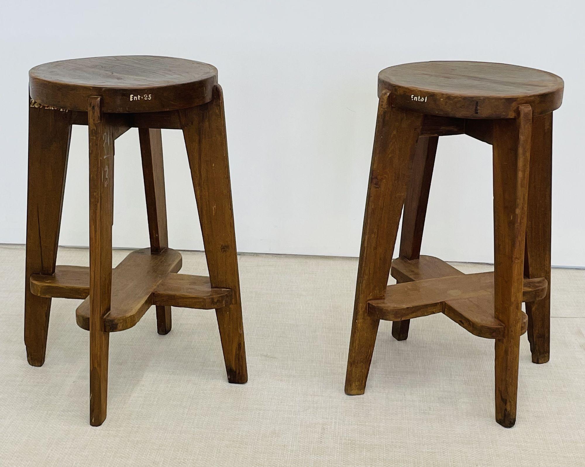 Pierre Jeanneret Teak Stools, Model PJ-SI-21-C
 
Pair of high round stools in solid teak having a leg assembly with four slightly slanted, tapered legs, connected by a double wide cruciform crosspiece.
 
France, India, c. 1960s
 
Each with markings