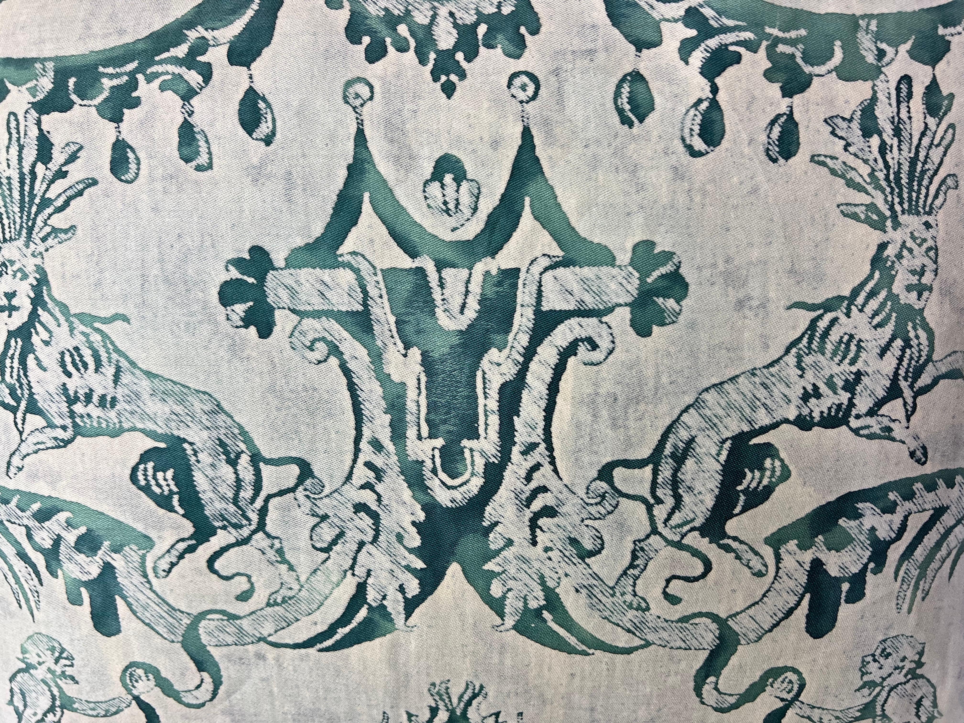 Pair of vibrant teal & white colored Marzianno patterned Fortuny textile pillows.  They depict Venetian lions and monkeys with garlands, acanthus leaves, and intricate details throughout.  They are backed with a rich colored teal velvet and finished