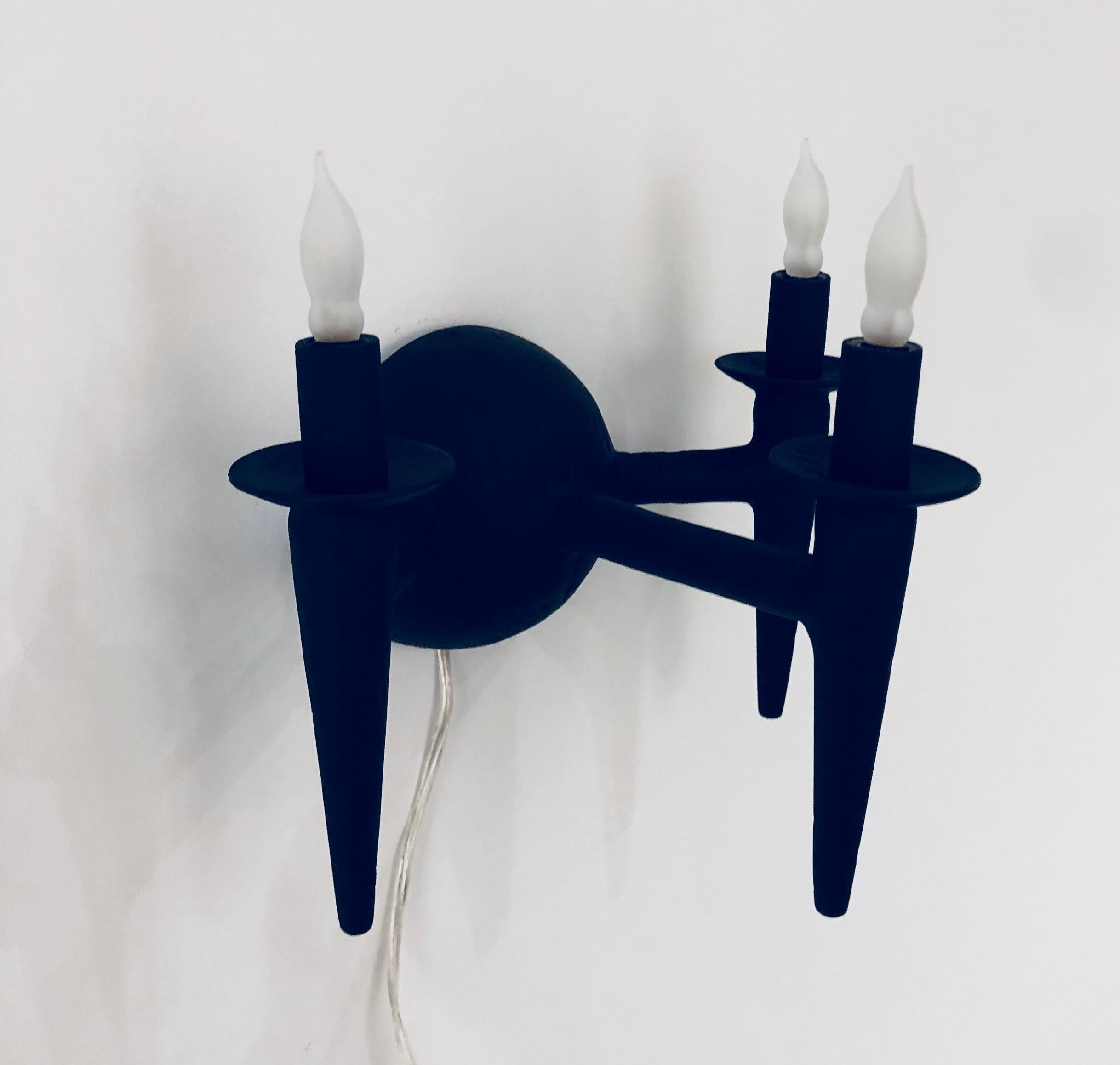 Dos apliques de pared con acabado de escayola. La luminaria utiliza tres bombillas con base de candelabro, potencia máxima de 60 vatios cada una. Las luces encajan en una caja J estándar. Los apliques tienen un acabado personalizado en negro mate.
