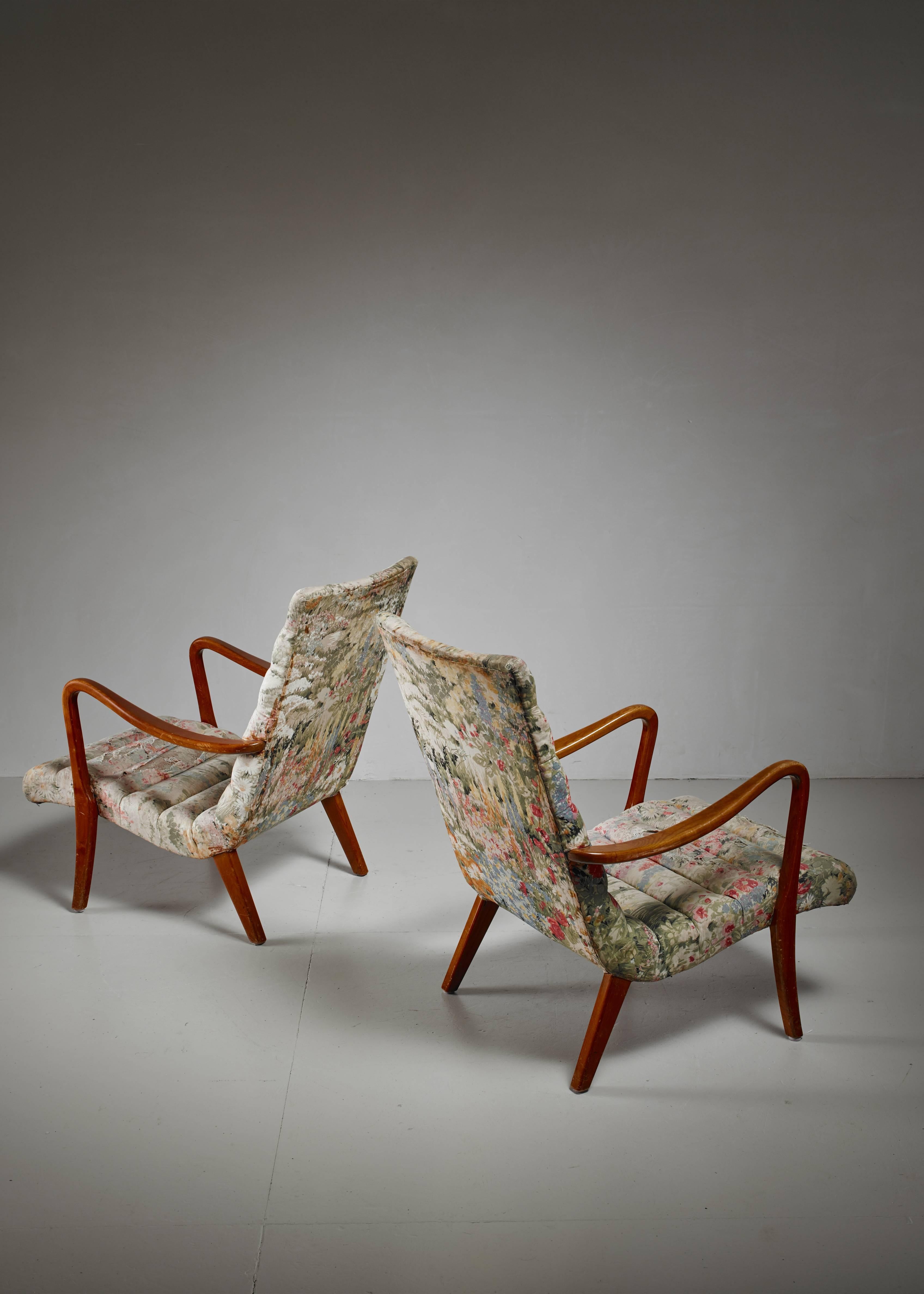 A pair of lounge chairs attributed to Axel Larsson for Svenska Möbelfabriken, Bodafors, 1940s. The chairs are made of a curved elm frame with a fabric upholstery with a beautiful floral pattern. The chairs have been reupholstered in the past and in