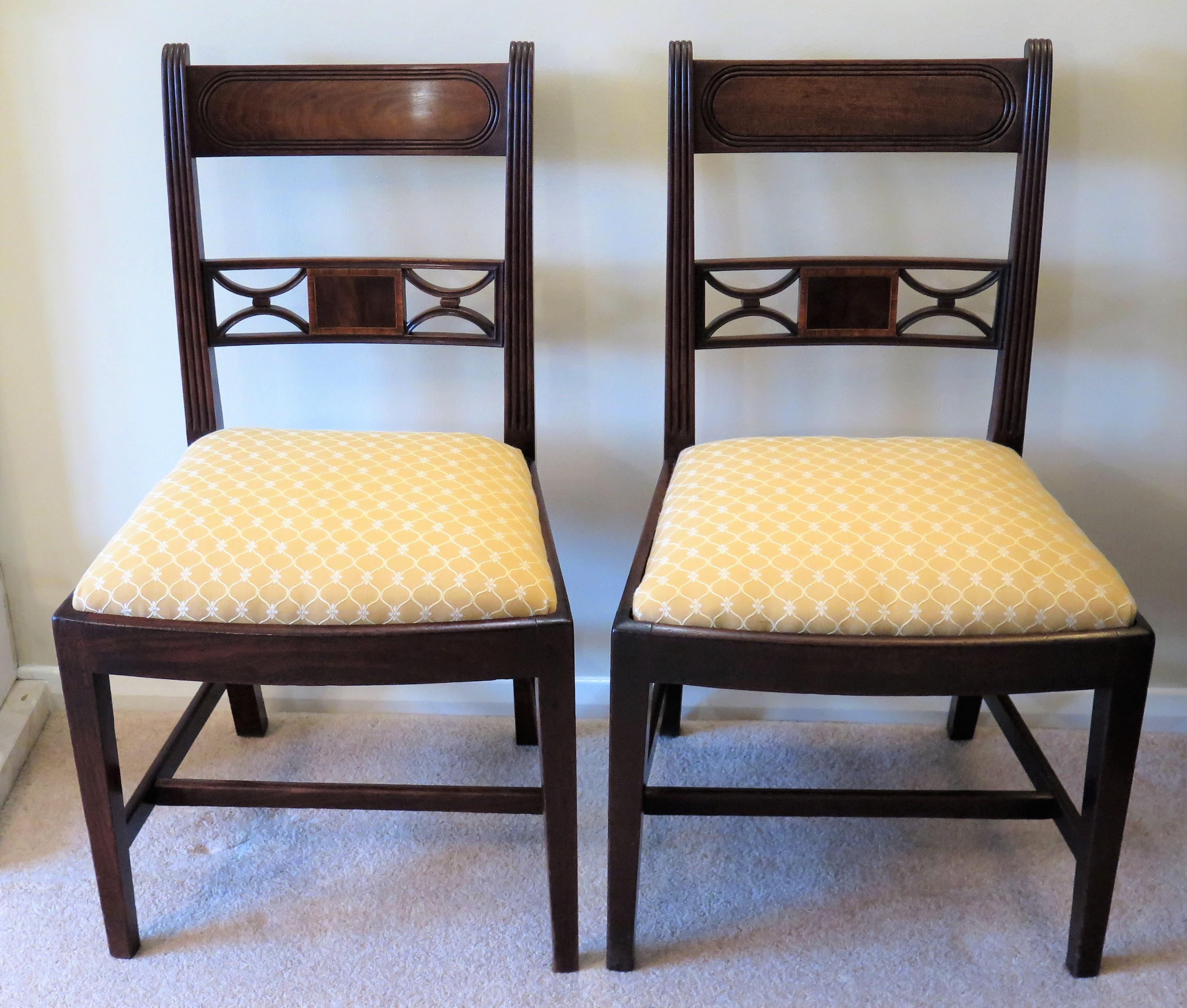 This a fine handmade pair of English, George 111rd, Sheraton period hardwood, possibly red walnut, dining or side chairs with good carved detail and reupholstered drop in seats, dating to the late 18th century, circa 1790.

The chairs have many